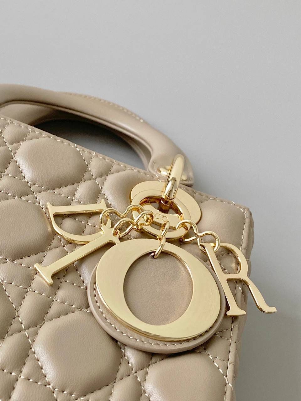 🈶奶茶色 𝗗𝗜𝗢𝗥 𝗟𝗮𝗱𝘆羊皮四格金扣 谁能拒绝这只刚出的新颜色啊 救命，真的太温柔了！很显气质 淡淡的色调，看着心情就很好 比去年的奶茶色要深，偏灰调些 进口原厂羊皮➕全钢五金，最高版本 （配6个五金图案 全套包装） size：20×16.5×8cm 4123m