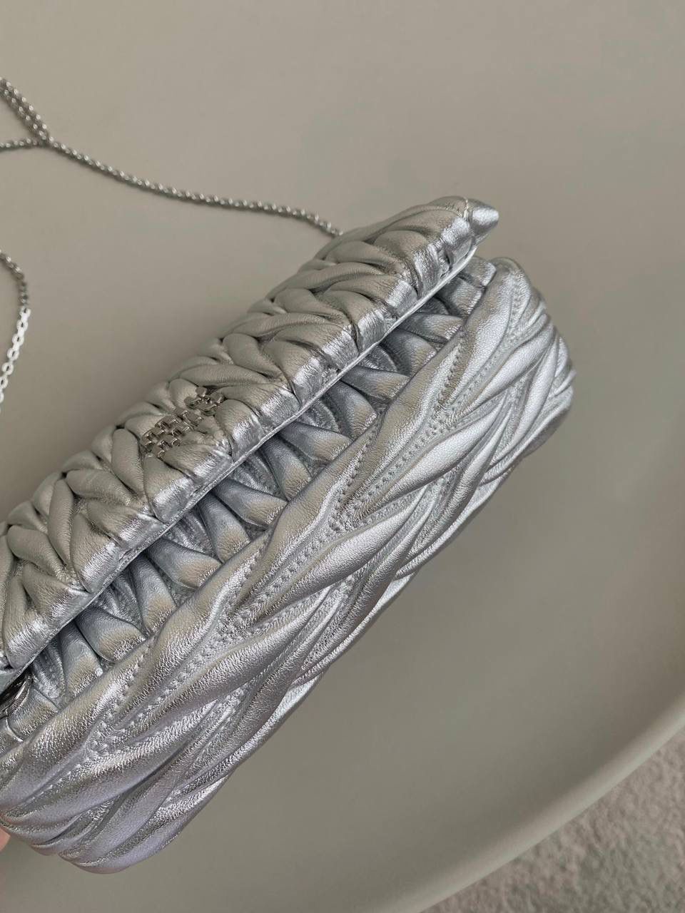 🈶银色 𝗠𝗶𝘂𝗠𝗶𝘂 𝐰𝐨𝐜链条包 咱就是说是不是不止我一个人喜欢这款链条包⛓真的好好看！精致的一塌糊涂，当一只手拿包也能彰显气质 我们用的是进口小羊皮！非国产皮料 肉眼可见的细腻，软软糯糯触感非常好！ 他家经典独特的褶皱工艺，是要有一定厚度 底料太薄了都做不出它的饱满 弹性 更不是市场通货干瘪瘪的褶皱，实在太假 我们新合作的老师傅在这细节上扣的很认真 一缕一折都有zp的神韵，且做到对版！！追求高品质的来 18×9.5×4cm #F0003m