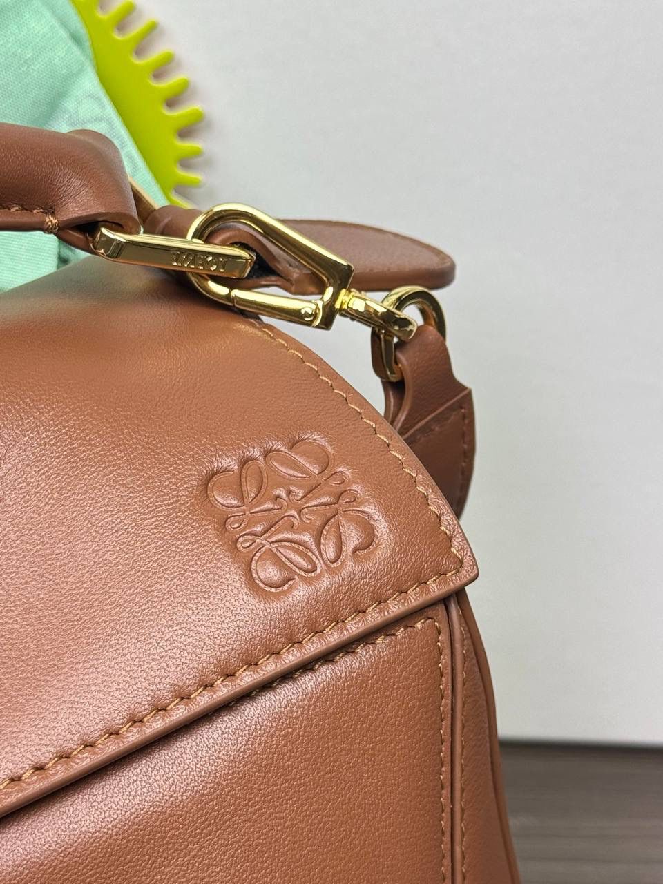 🎈【周年限定】 小号纳帕羊皮𝗙𝗲𝗮𝘁𝗵𝗲𝗿𝗹𝗶𝗴𝗵𝘁 𝗣𝘂𝘇𝘇𝗹𝗲手袋👜 ——山核桃色到货❤️ 尺寸：𝟮𝟰-𝟭𝟬.𝟱-𝟭𝟲.𝟱𝗰𝗺 编码：061610【配全套礼盒】 ✅延续经典老款𝗣𝘂𝘇𝘇𝗹𝗲做法，全新𝗣𝘂𝘇𝘇𝗹𝗲内外采用柔软轻盈的纳帕羊皮材质，为手袋注入随性慵懒的风格。 ✅该款饰有旋转卡扣，铰链式拉链头，一个外部拉链后袋，一个内部插袋，以及可拆卸式的𝗟𝗢𝗘𝗪𝗘烫金或烫银标签，饰有隐秘口袋和气球骰子，底部长方形金属脚钉。搭配可拆卸可调节长肩带，可肩背、斜挎或手提。