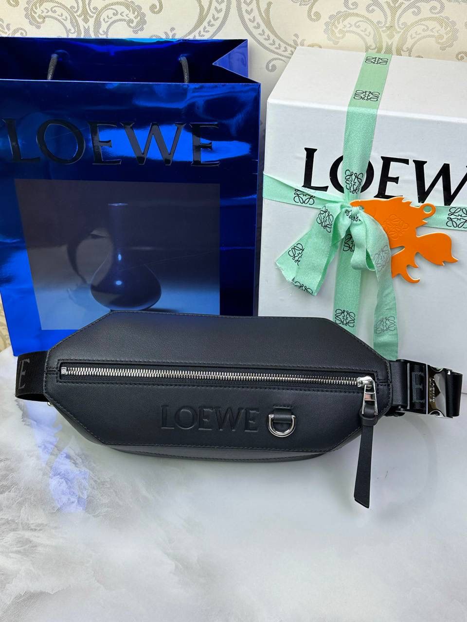 ———变形𝙎𝙡𝙞𝙣𝙜斜挎腰包👜 （新款黑色到货👉🏻） 尺寸：𝟑𝟐.𝟓-𝟗-𝟏𝟐.𝟑𝐜𝐦 编码：060402 👉🏻正面饰品牌标志性𝙇𝙤𝙜𝙤，搭配可调节𝙇𝙊𝙀𝙒𝙀织带，可打开以改变手袋容量并实现多种携带方式⭐️ 👉🏻经典小牛皮，皮质细腻柔软。可斜挎或者作为腰包携带，内里容量大，可容纳日常出行所需⭐️ 👉🏻独家全套礼盒套装➕独家高端品质，好货全在我手，送礼佳品⭐️