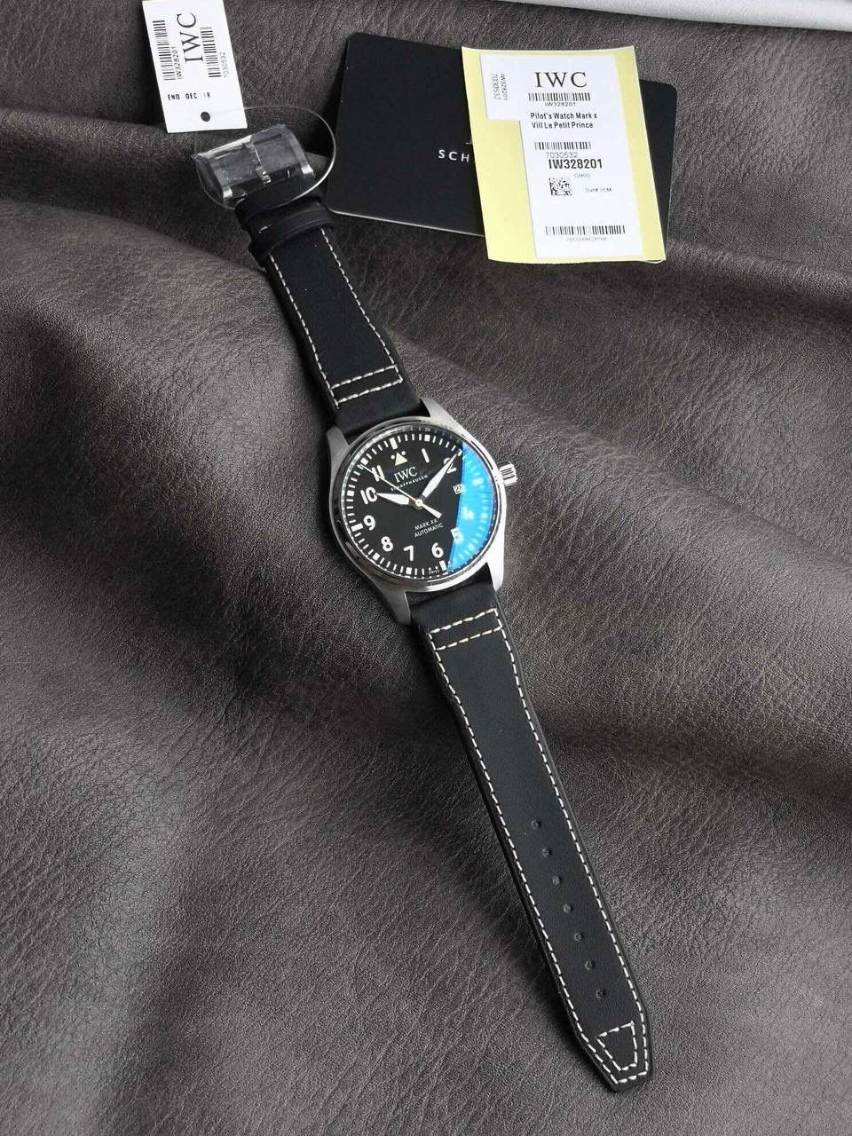 V7厂此款表盘与原装同样，仍配备通透度同步原装的进口双面防反光凸状蓝宝石镜面，刻度和时标依然保持白色印制工艺，与马克18的区别增加了3、6、9、12时标的长度，夜光条变化成夜光图层，阿拉伯数字时标则整体向表盘中央靠近，12点“IWC”标志略微上移，三角刻度也改为水滴夜光呈现全新的视觉比例。日历统一白底黑字台阶窗口也位同数字的一个圆轨道上，与背景形成更醒目对比，盘面上的荧光元素和指针在任何光线条件下，都能确保可读性。时针、分针现在经过镀铑处理，并且指针针尾有稍微做弯（注:有别于市场版本，v7细节把控向来严谨，放大来看亦无可挑剔） V7厂独家专用马克进口牛皮，其材料，做工，佩戴感100%同步原装，全新开模的表扣，打磨刻字功底扎实，表扣与表带均采用自拆装置，实用功能是EasX-CHANGE®简易更换系统，无需借助其他工具，可以轻松更换链带，难辨雌雄。这也是有别与市场版本特点。 V7厂仍采用进口瑞士全新SW300机芯，性能同样出色，精准恒久，无返修烦恼！V7亦同时提供亲民版的海鸥2892稳定版供选，其外观细节均与瑞士版本一样。