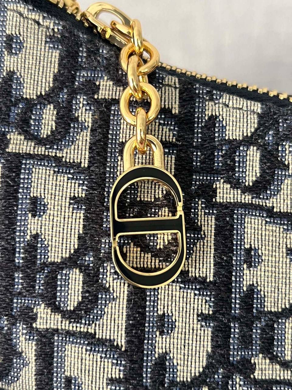 CD LOUNGE 手袋蓝色 Oblique 印花👜✨ 独家渠道货 独家腋下包老花 尺寸：26 x 15 x 5.5 厘米 这款 CD Lounge 手袋是2023夏季新品，彰显 Dior 的现代审美与高订风范。 采用蓝色 Oblique 印花面料精心制作，突显 Dior 经典图案。 经典链条与皮革搭配，交替饰以金色饰面金属和同色调珐琅链环，可折叠设计，可肩背或手提。 拉链开合搭配 CD 拉链头 可调节肩带，链条部分由金色饰面金属和与皮革同色调的珐琅 CD 链环组成，搭配皮革带 内含防尘袋