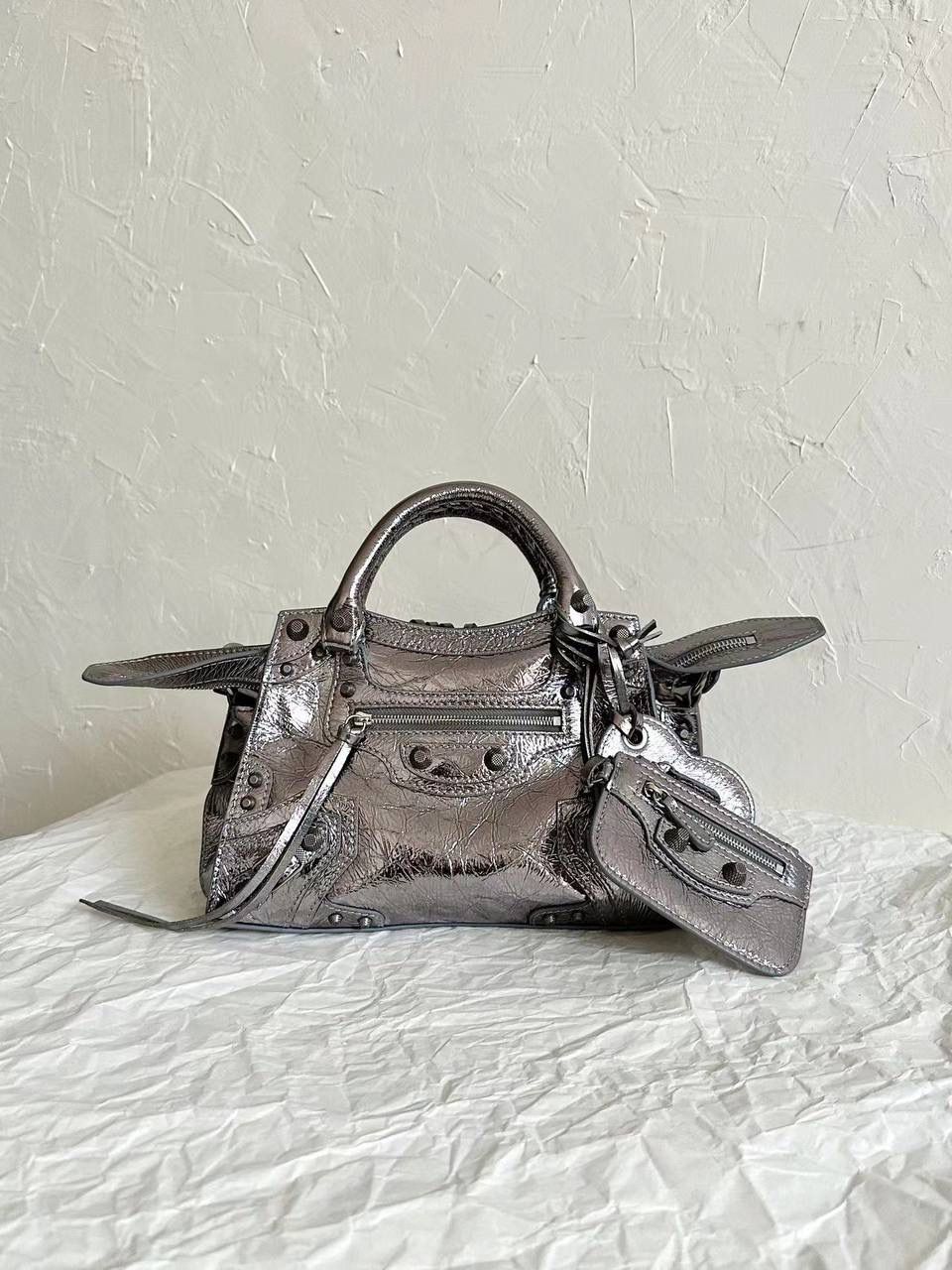 销量王🔥 Neo classic 机车包xs 首先声明，我爱一切机车元素 无论是le cagole还是这只neo 喜欢大容量的姐妹冲这只 油蜡皮的不规则摔纹配上大量的五金配件 还有流苏拉牌➕爱心镜子➕零钱包挂件 极繁的魅力由此而来～ 辣妹酷妹冲冲！ 26×17.8×11.4cm700940m