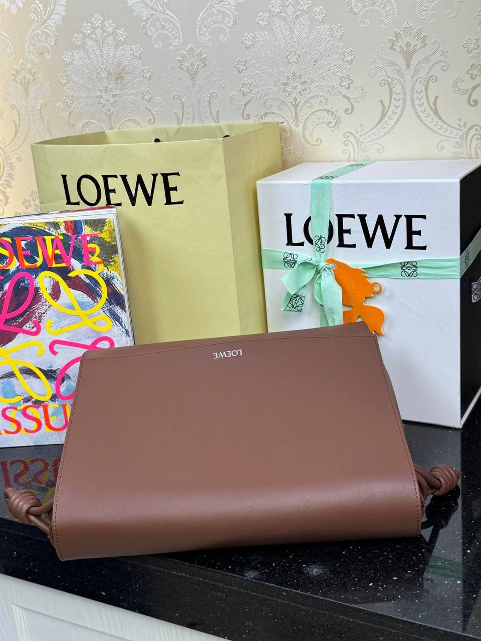 【全皮布朗尼色】 𝙇𝙤𝙚𝙬𝙚 𝙁𝙡𝙖𝙢𝙚𝙣𝙘𝙤 𝙎𝙖𝙩𝙘𝙝𝙚𝙡 福袋款邮差包 ➕刺绣🅾️字母宽肩带 编码：062404 尺寸：𝟑𝟒-𝟏𝟐-𝟐𝟒𝐜𝐦 新款以经典福袋收缩打结为元素，采用内部麂皮➕外部进口小牛皮➕刺绣字母宽肩带的精致搭配打造全新升级款邮差包🅰️，可斜挎、肩背和手提，超大容量满足日常所需🎈