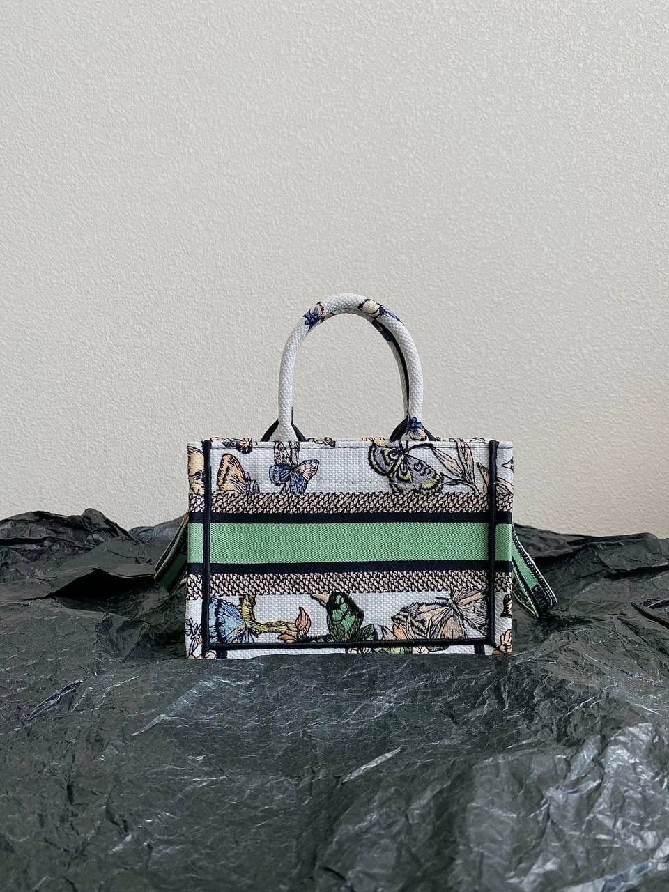 🈶绿色蝴蝶迷你 𝗖𝗗 𝗕𝗼𝗼𝗸 𝗧𝗼𝘁𝗲 24圣诞限定🎄 圣诞季这一波𝗗𝗜𝗢𝗥真的稳赢 浪漫的蝴蝶刺绣 象征着自由和转变 高级的配色 精致的造型与细节设计，无不透露出一种温柔而魔法般的美感🎀 呜呜真的太好看了，姐妹们必冲！ 21.5×13×7.5cm