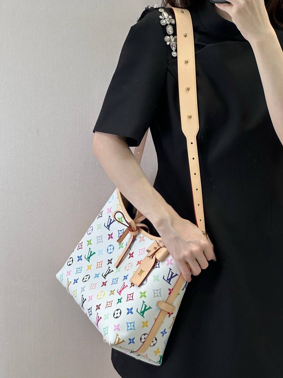 LV 白三彩 Carryall 👜✨ 这是那种—— 一背上街，别人会多看你两眼的包 🌈 白底三彩像把颜色撒进 Monogram 里， 樱花、熊猫跳出来那一刻， 整个包都在发光 ☀️ 不是甜腻，是很有态度的可爱。 Carryall BB 包型软软的、容量却很能装， 通勤不无聊，出游更加分。 蝴蝶结、链条点缀得刚刚好， 甜酷之间拿捏得很准。 如果你已经看腻普通老花， 那这只，就是春天给你的答案 🌸 📏 25 × 31 × 14 cm