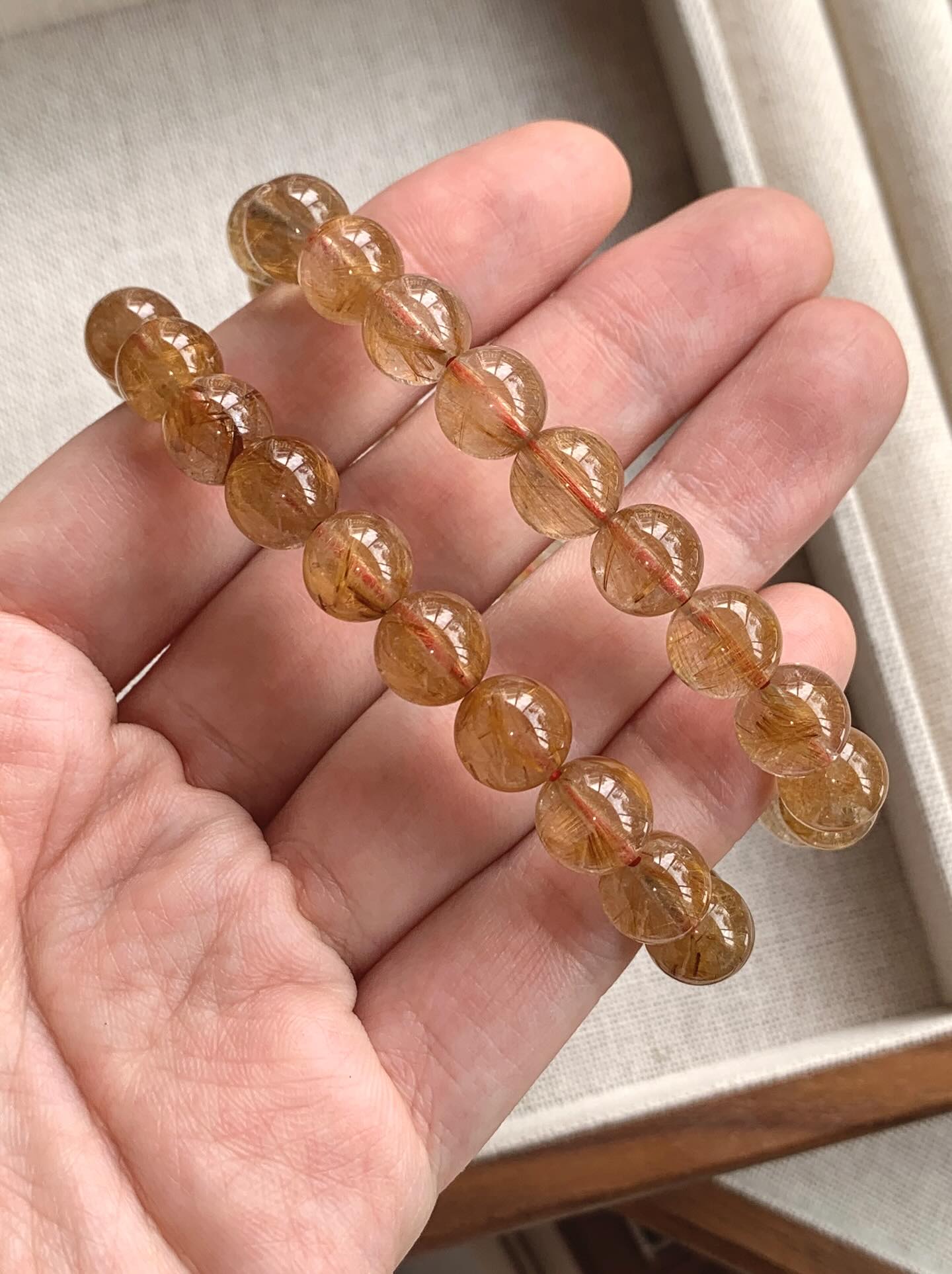 高货咖啡金发晶 ｜High Grade Gold Rutile 9.1/9.3mm RM218 金发晶被认为具有强大的财富能量，可以增强事业运和财运，同时也能提升自信、勇气和果断力。此外，它还能帮助稳定能量场、辟邪化煞、增进人际关系，并对身体健康有益，特别能帮助消化系统和提升活力Gold rutile quartz is believed to boost awareness, creativity, and confidence while also acting as an energy amplifier for other crystals. It helps to balance emotions, ease loneliness and depression, and promotes forgiveness. This crystal is also considered a powerful aid for manifestation, helping to ground divine energy and activate creative inspiration. #金发晶 #goldrutile #天然水晶 #水晶手串 #马来西亚水晶网店 #gemstone #naturestone