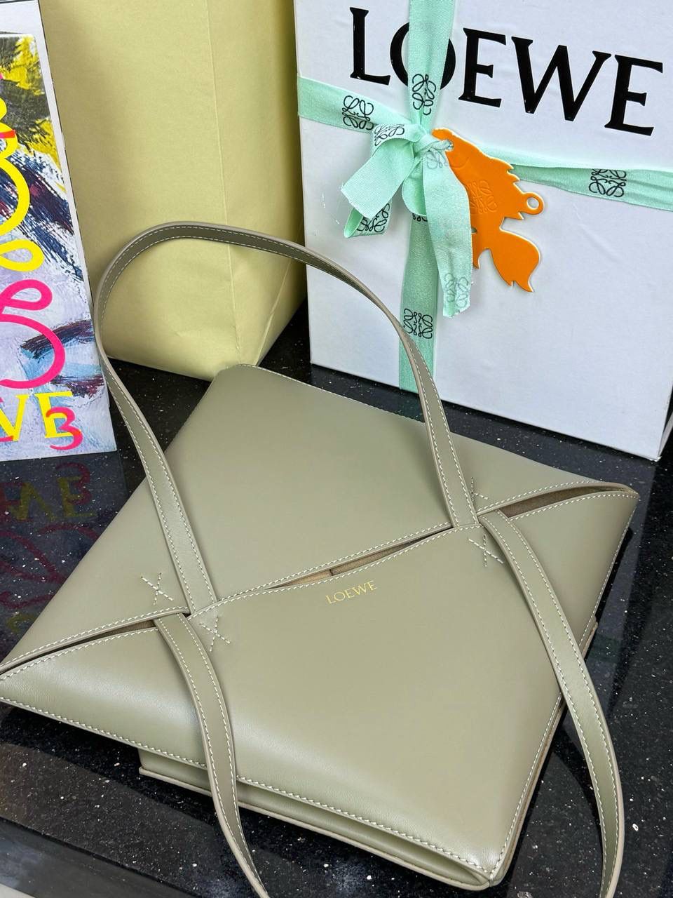 *中号𝐏𝐮𝐳𝐳𝐥𝐞 𝐅𝐨𝐥𝐝折叠手袋👜*（桉树绿） ——全新【𝗡𝗘𝗪】升级‼️ 延续经典𝙋𝙪𝙯𝙯𝙡𝙚的标志性几何裁剪设计，新晋顶流🅰️𝙋𝙪𝙯𝙯𝙡𝙚 𝙁𝙤𝙡𝙚 𝙏𝙤𝙩𝙚以折纸包为灵感，升级成🉑完全折叠‼️的结构，立体与平面任意切换，出差旅行🧳必备单品。小牛皮材质轻且柔软，𝐌𝐢𝐧𝐢尺寸搭配一条可拆卸式肩带，手提，肩背，斜挎多样化背法✨ 尺寸：𝟐𝟓.𝟓-𝟏𝟒.𝟓-𝟑𝟏.𝟓𝐜𝐦 款号：052316