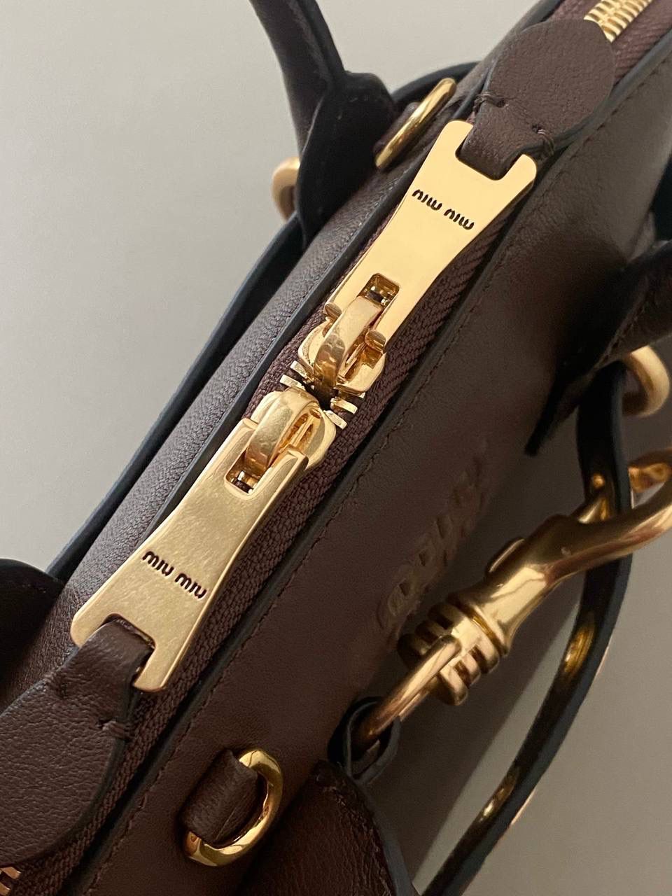 🈶石南木色，迷你 𝗠𝗶𝘂𝗠𝗶𝘂24秋冬贝壳包 年度爆炸款来啦 | 真心被夸爆 没有过分夸张的设计，有着时髦且个性的圆弧包型，形似贝壳，看着很轻松又舒适一点也不会给人压力 双向拉链在保证实用性的同时让它充满了复古的调性，搭配上腰带式设计细节，时髦有态度 面料手感软糯，拎在手上可以切确感受到高级质感 迷你：8×13×21cm #F0022m 小号：16.5x28x10cm 大号：33x17x11cm