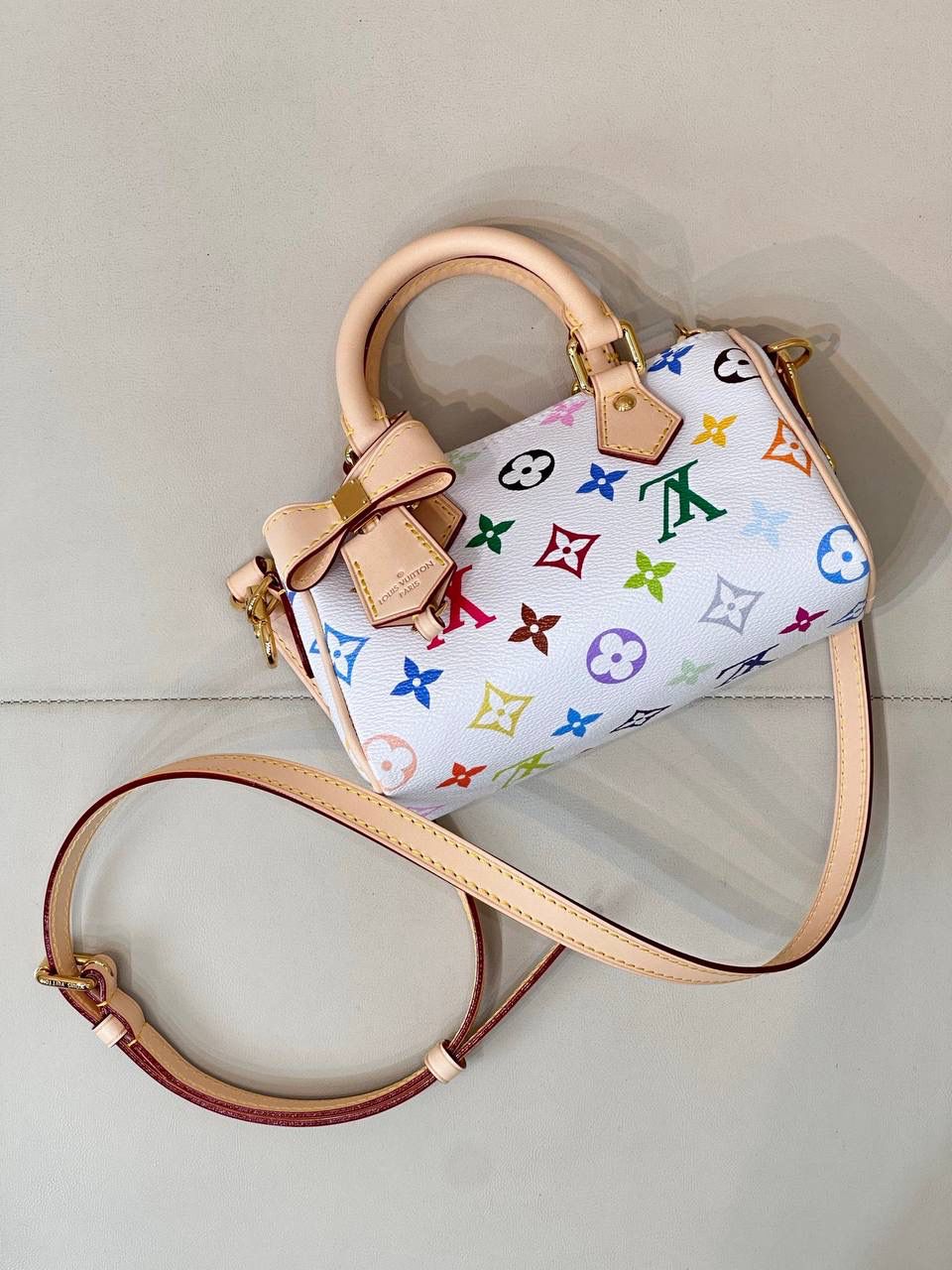 LV村上隆联名白三彩Nano Speedy来啦！姐妹们快看这个神仙包包！👜🌈 白色打底+彩色老花图案，配上祖传小锁头钥匙包，简直是《Mean Girls》千禧辣妹的标配！全新数码印花绝绝子，太阳花和熊猫都像要跳出来，阳光下自带ins滤镜特效！别看它巴掌大，手机口红💄钥匙全塞得下，从此打脸那些说mini包不实用的人！ 尺寸：16-10-7.5cm
