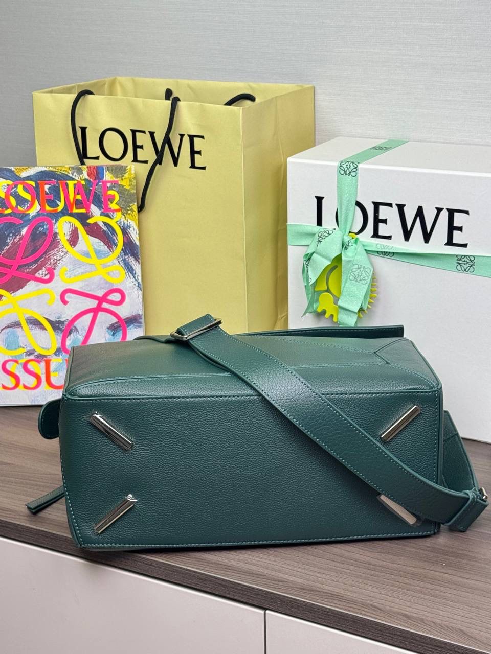 🎈【全钢】大号鹿皮𝘗𝘶𝘻𝘻𝘭𝘦* ——【👉🏻常青色到货✅】 尺寸：𝟑𝟐.𝟓-𝟏𝟒.𝟓-𝟐𝟑.𝟓𝐜𝐦 编码：260403 【配全套包装】 ❤️经典拼图系列•不规则立体几何设计•最具辨识度的立体廓形和几何美学•顶级进口皮搭配德国沙菲线•独家定制五金•𝗬𝗞𝗞拉链拉头。 ❤️该款大号采用鹿皮革制成•绒面内里•搭配一条可拆卸可调节的皮肩带•肩背斜挎或手提多样化背法。