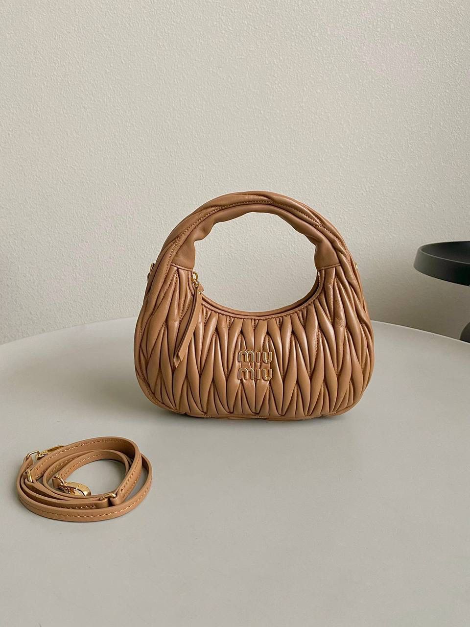 🈶焦糖小号 𝗠𝗶𝘂𝗠𝗶𝘂 𝗪𝗮𝗻𝗱𝗲𝗿 𝗛𝗼𝗯𝗼褶皱腋下 火爆全网都不用多说，人手一只的程度 我们用的是进口小羊皮！非国产皮料 肉眼可见的细腻，软软糯糯触感非常好！ 他家经典独特的褶皱工艺，是要有一定厚度 底料太薄了都做不出它的饱满和弹性 更不是市场通货干瘪瘪的褶皱，实在太假 我们新合作的老师傅在这细节上扣的很认真 一缕一折都有zp的神韵，且做到对版！！ 追求高品质的来 小号：17×20×6cm，#F0013m 中号：18x25x7cm