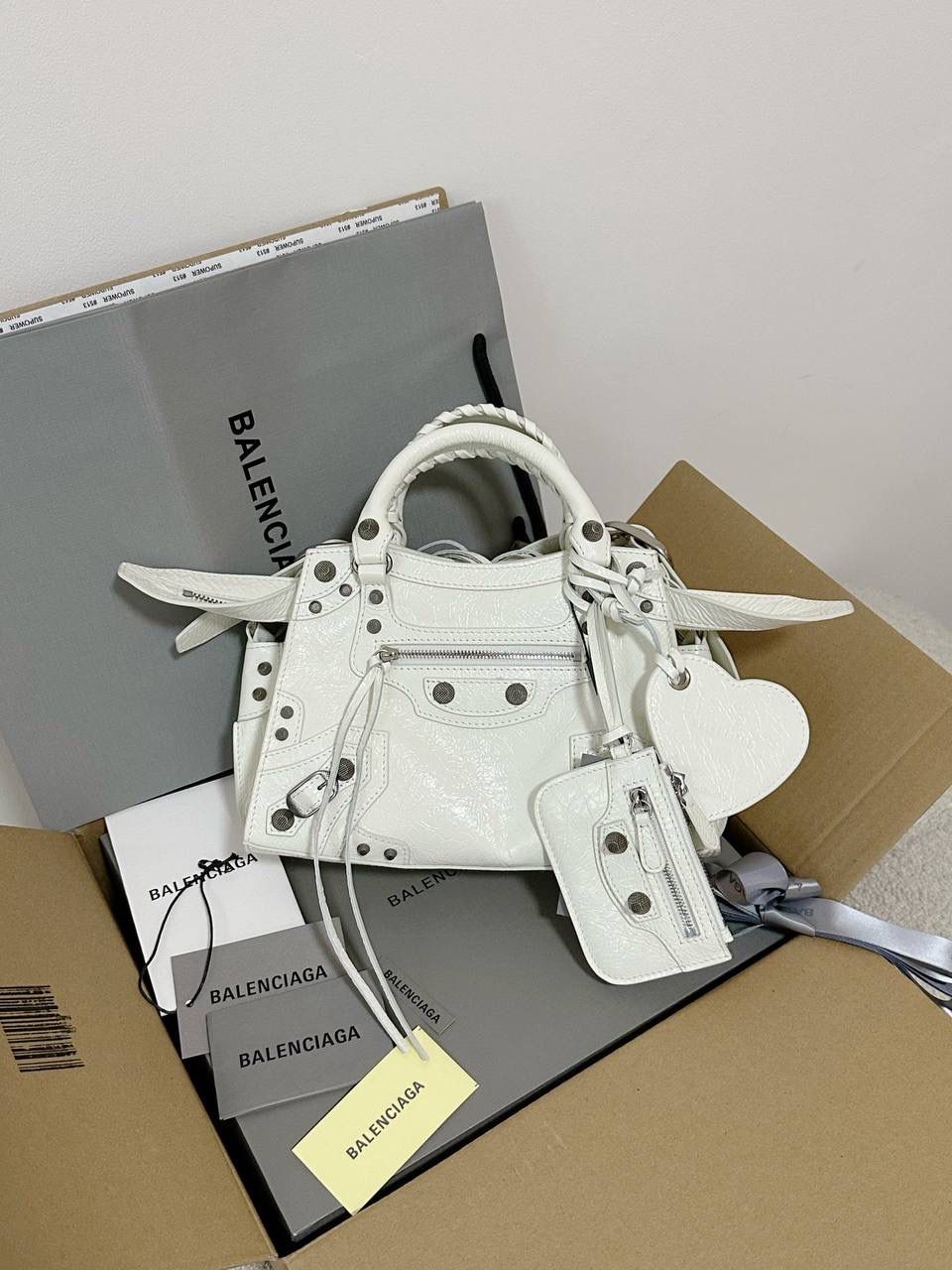 ba1enciaga Neo cagole 机车包xs 白银🐇 首先声明，我爱一切机车元素 无论是le cagole还是这只neo 喜欢大容量的姐妹冲这只 油蜡皮的不规则摔纹配上大量的五金配件 还有流苏拉牌➕爱心镜子➕零钱包挂件 极繁的魅力由此而来～ 辣妹酷妹冲冲！ 26×17.8×11.4cm700940m