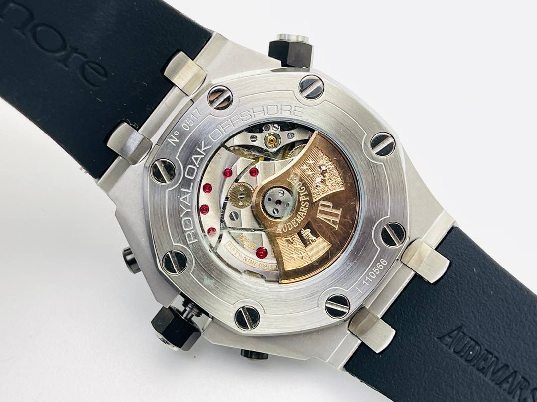 爱彼A P皇家橡树系列水果腕表！ 型号：26703 跑秒计时自动机械男表！搭载原版cal.3124机芯 直径：42MM！ 1⃣️表壳材质选用的904L精钢，经过CNC一次成型锻造了42MM的表径，表壳在经过拉丝工艺多次打磨抛光后做到了无懈可击，包括螺钉也一致还原！ 2⃣️表盘字面格纹错落有致，立体感很强。刻度线粗细程度以及长短均与正品保持一致。条钉时标内部填充超强夜光材料。两组小圆盘对称分布，就像两只小眼睛。盘面内有一圈一圈的放大环，细节处理很到位。 3⃣️橡胶表带表面的磨砂质感很强.采用无味不沾灰尘的进口橡胶，只为提高佩戴的舒适感！ 4⃣️前后玻璃都采用蓝宝石水晶镜面玻璃，镜面通透性也很强。这款腕表采用3124机芯，做到了外观和正品的极其相似，走时精准稳定！