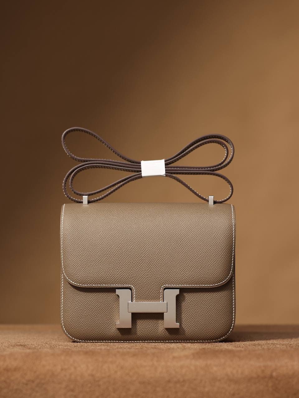 Hermes 爱马仕 #Constance 19大象灰 银扣👜✨ Epsom牛皮 单肩斜挎包 尺寸：19*15*4 cm 这款采用的是Epsom牛皮,纯原皮，和专柜用的是一个渠道的真皮 什么是Epsom牛皮？ 皮质：ep皮/手掌纹、一岁以上的公牛皮 软硬度：偏硬 纹理：皮面颗粒小的细腻皮纹，有点光泽感 特点：硬朗有细纹的牛皮皮质。细纹是进过后期处理的，比较硬质立体，长期贮存也不容易变形。自重轻，不易刮伤，非常耐磨实用。 所以每个H的款式用的皮都不一样，都是非常有讲究的✅
