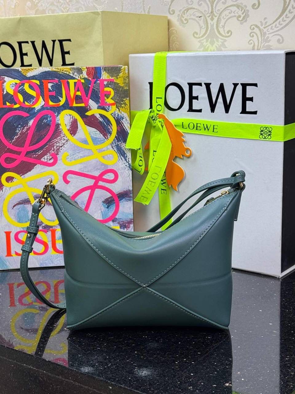 ♥️𝙋𝙪𝙯𝙯𝙡𝙚 𝙁𝙤𝒍𝒆 ——【香根草绿】 尺寸：𝟐𝟑-𝟔.𝟓-𝟏𝟓.𝟓𝐜𝐦 编码：522404 🎈经典几何为造型，以及柔软细腻的Napa牛皮，升级为可完全折叠的手拿包。 🎈自带一根🉑拆卸🉑调节的肩带，一包多背，多样化风格，秀场大放异彩😃日常实用性强👌 🎈配全套专柜礼盒🎁，给你满满的仪式感👀