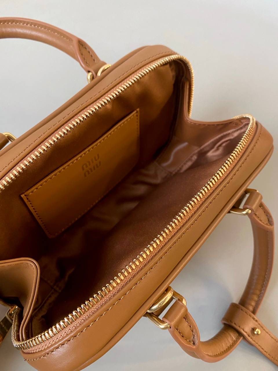 🈶干邑色，迷你 𝗠𝗶𝘂𝗠𝗶𝘂保龄球，大爆款 新尺寸也太可爱了！ 喜欢小包的姐妹这只必买！它要比小号小一些也窄一些 就巴掌大小，但容量还挺大的 装俩部手机都绰绰有余，日常够用 肩带长短也很ok，手拎斜挎都好看 反正放心冲就是了！拥有它，上班牛马的心情都会被治愈～ 迷你：19×10×5cm #F0011m 小号：22x10.5x7.5cm 大号：27x12x9cm