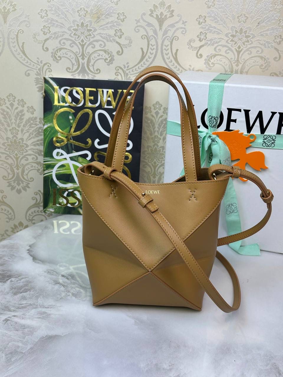 *𝐌𝐢𝐧𝐢 𝐏𝐮𝐳𝐳𝐥𝐞 𝐅𝐨𝐥𝐝折叠手袋👜* ——全新【𝗡𝗘𝗪】升级‼️ 延续经典𝙋𝙪𝙯𝙯𝙡𝙚的标志性几何裁剪设计，新晋顶流🅰️𝙋𝙪𝙯𝙯𝙡𝙚 𝙁𝙤𝙡𝙚 𝙏𝙤𝙩𝙚以折纸包为灵感，升级成🉑完全折叠‼️的结构，立体与平面任意切换，出差旅行🧳必备单品。小牛皮材质轻且柔软，𝐌𝐢𝐧𝐢尺寸搭配一条可拆卸式肩带，手提，肩背，斜挎多样化背法✨ 尺寸：𝟏𝟔.𝟓-𝟗.𝟓-𝟐𝟎cm 款号：052322