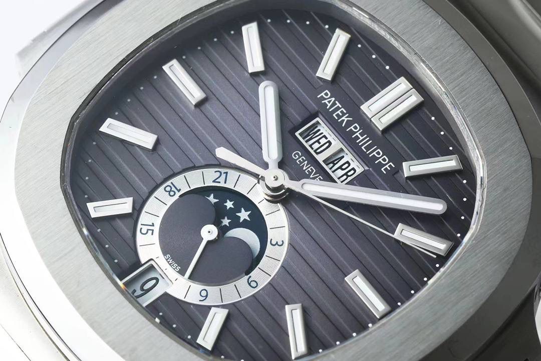 新晋 “钢王”百达翡丽Ref.5726/1A Nautilus系列年历腕表正式上位！鹦鹉螺全系列一贯设计的旋窗造型表壳，PPF与正品工艺一致的采用锻纹修饰和抛光工艺处理构成鲜明对比，1:1还原了正品每个细节。盘面深邃蓝色并装饰有水平横纹浮雕图案颜色从中央向四周扩散，星期月份双视窗和日期窗黑字白底辨识度高，24小时显示盘附带月相十分高雅，整体给人的感觉是独特又优雅，是最美的鹦鹉螺之一。背面蓝宝石镜面，搭载PPF独家研发的324S QA LU 24H/303自动一体机械机芯，21K的大金陀让上链效率更高，红宝石轴承日内瓦纹下方的鱼鳞纹精致无比，机芯打磨依旧是业内标杆级别。作为PPF首款年历腕表能正确辨别出大小月，每年只需要在3月1日调节一次日期即可。