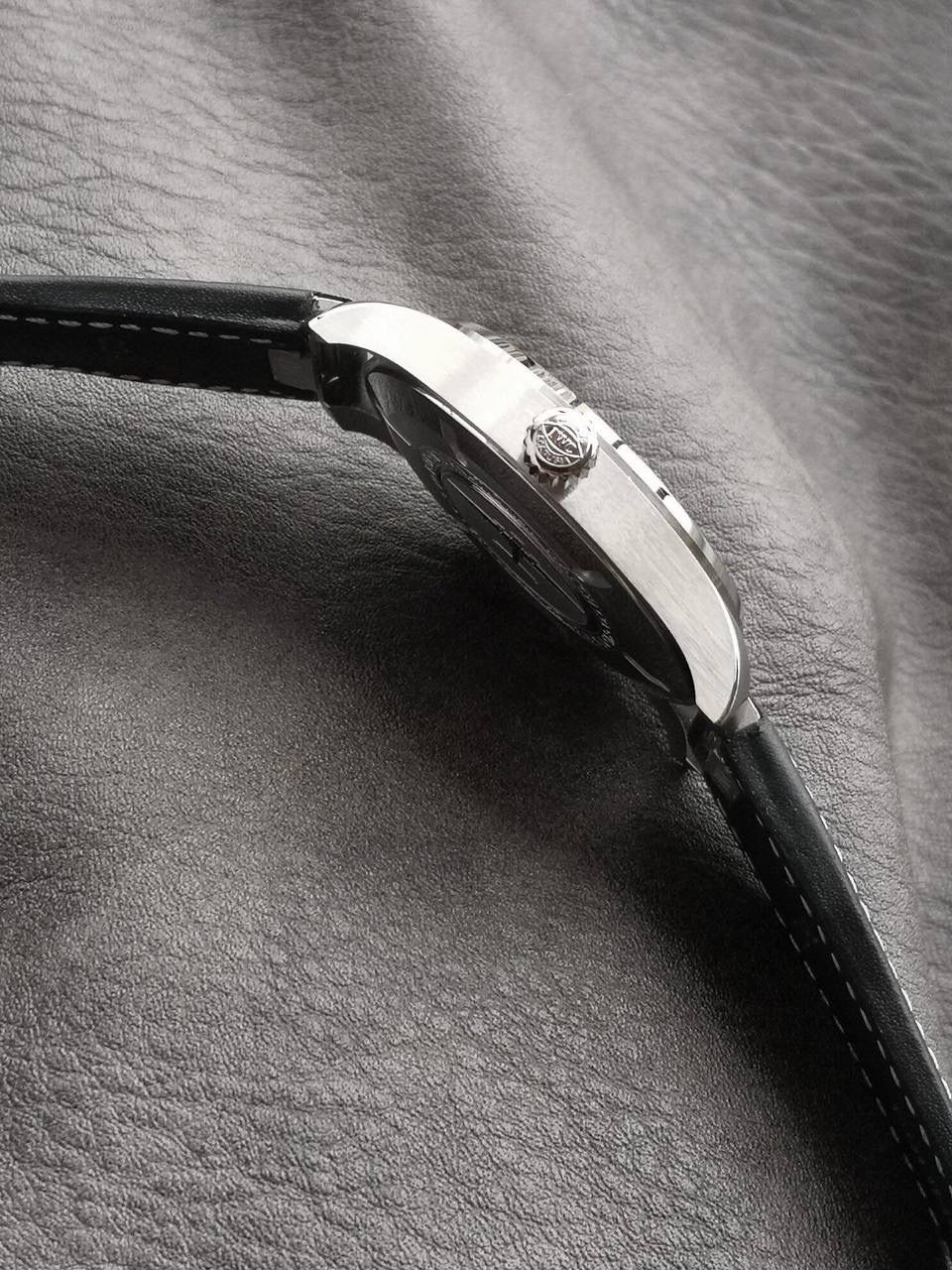 V7厂此款表盘与原装同样，仍配备通透度同步原装的进口双面防反光凸状蓝宝石镜面，刻度和时标依然保持白色印制工艺，与马克18的区别增加了3、6、9、12时标的长度，夜光条变化成夜光图层，阿拉伯数字时标则整体向表盘中央靠近，12点“IWC”标志略微上移，三角刻度也改为水滴夜光呈现全新的视觉比例。日历统一白底黑字台阶窗口也位同数字的一个圆轨道上，与背景形成更醒目对比，盘面上的荧光元素和指针在任何光线条件下，都能确保可读性。时针、分针现在经过镀铑处理，并且指针针尾有稍微做弯（注:有别于市场版本，v7细节把控向来严谨，放大来看亦无可挑剔） V7厂独家专用马克进口牛皮，其材料，做工，佩戴感100%同步原装，全新开模的表扣，打磨刻字功底扎实，表扣与表带均采用自拆装置，实用功能是EasX-CHANGE®简易更换系统，无需借助其他工具，可以轻松更换链带，难辨雌雄。这也是有别与市场版本特点。 V7厂仍采用进口瑞士全新SW300机芯，性能同样出色，精准恒久，无返修烦恼！V7亦同时提供亲民版的海鸥2892稳定版供选，其外观细节均与瑞士版本一样。