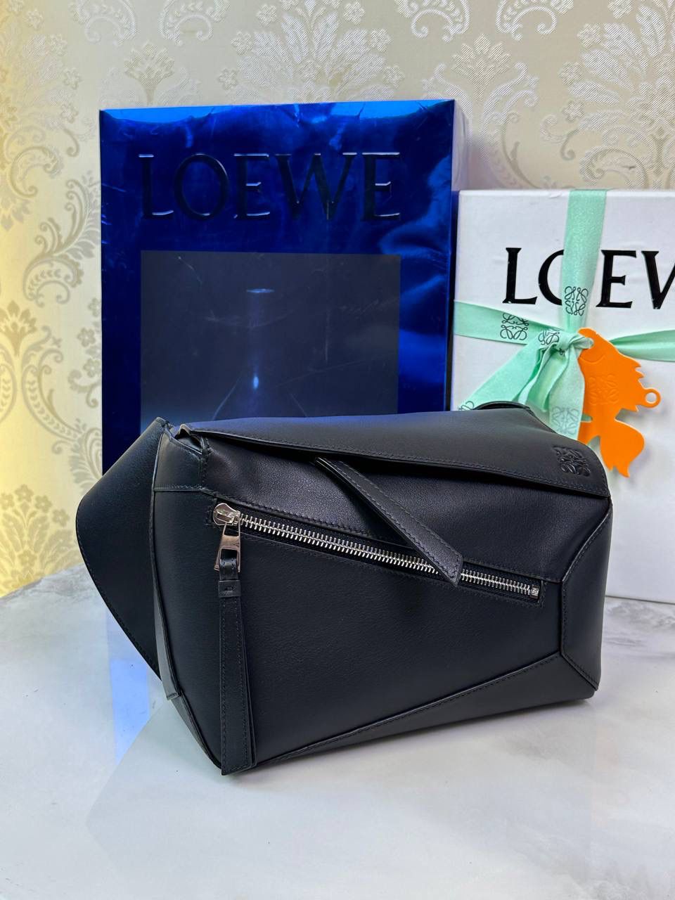 ⭐️最新升级版𝟮.𝟬-𝗣𝘂𝘇𝘇𝗹𝗲腰包⭐️ （黑色 到货‼️） 尺寸：𝟮𝟰-𝟭𝟬.𝟱-𝟭𝟲𝗰𝗺 款号：052343 👉🏻长方体形状和精确的切割技巧创造出Puzzle 腰包以及独特的几何线条成为 “Loe罗家”的著名代表作~ 👉🏻金属搭扣开合，刻有标志logo徽标，可调节肩带，翻盖大容量插袋和一个外部拉链口袋，🐂柔软细腻napa小牛皮，正品Ykk五金，Anagram压纹，人字纹棉麻帆布内里 👉🏻（男女♀♂同款）大小非常合适。胸包、背包、单肩、斜挎 腰包五种背法任你解锁🔒 👉🏻 （独家背景➕独家品质➕独家包装➕独家控制对版细节📦➕精致全套礼盒套装❤️） 重点：让你花最少的钱💰体验最大的仪式感❤️