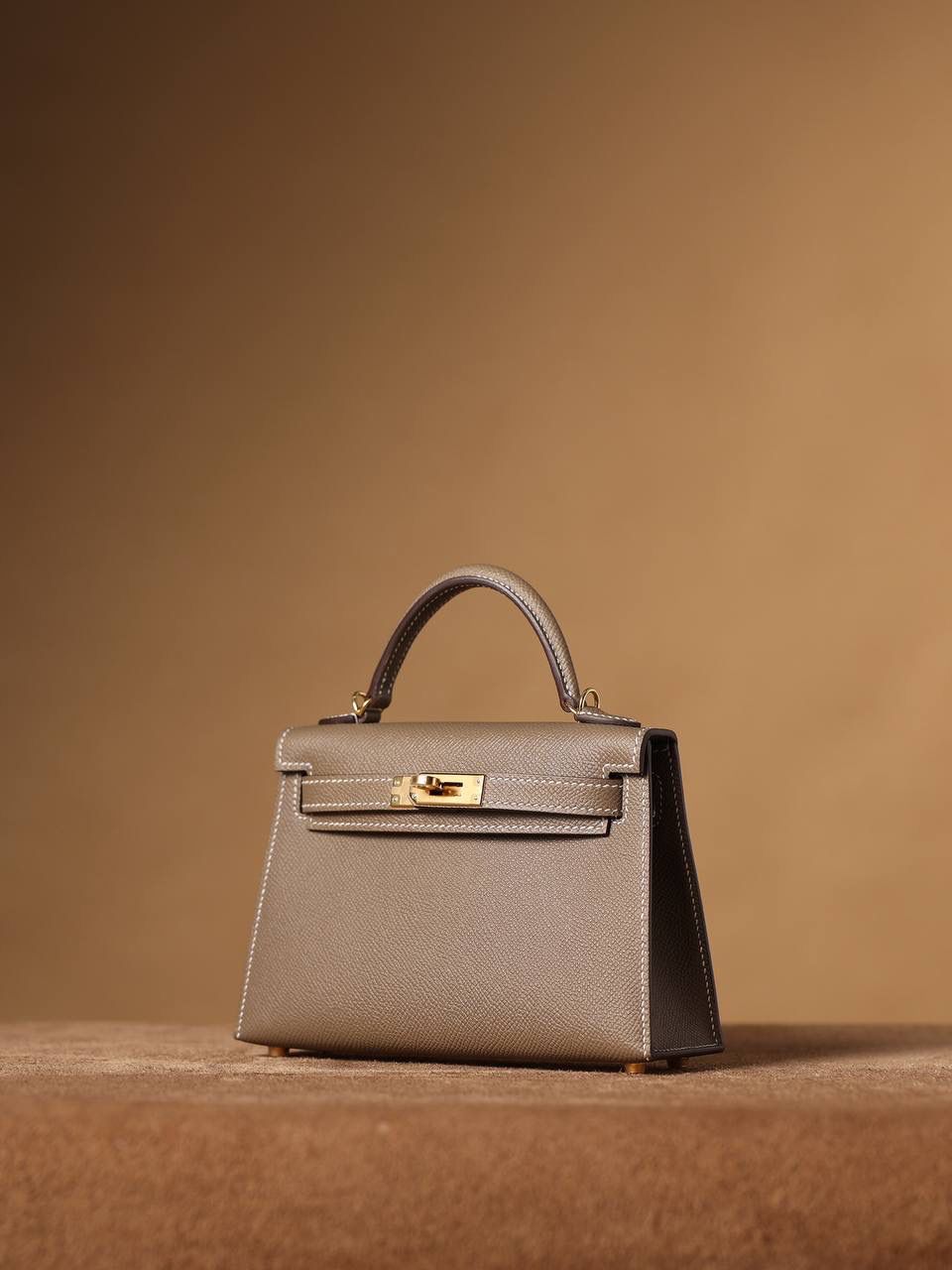 HERMES 爱马仕 Mini Kelly 二代 👜✨ Mini Kelly 二代 大象灰金扣 高清实拍图 尺寸：19*12*6cm Hermès爱马仕是世界著名的奢侈品品牌，1837年由Thierry Hermès创立于法国巴黎。爱马仕早年以制造高级马具起家，迄今已有180年的悠久历史。 其整个品牌从整体到细节以及专卖店，都弥漫着浓郁的以马文化为中心的深厚底蕴🎀