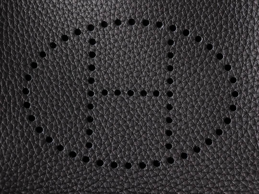 HERMES爱马仕Evelyne 16伊芙琳黑色金扣👜✨ TaurillonMaurice 小公牛皮 尺寸：16*18*5cm 爱马仕Evelyne伊芙琳 Evelyne包的设计灵感来自于一种名为“马鞍袋”的马具袋，这是一种常用于骑手和马车夫的袋子，用于储存和运输马具和其他必需品。 爱马仕将这种马具袋的经典元素与品牌的手工艺传统相结合，打造出了具有时尚感和功能性的包包。 因此，伊芙琳包不仅是一款实用的手提包，同时也代表着品牌深厚的历史和文化传统❤️