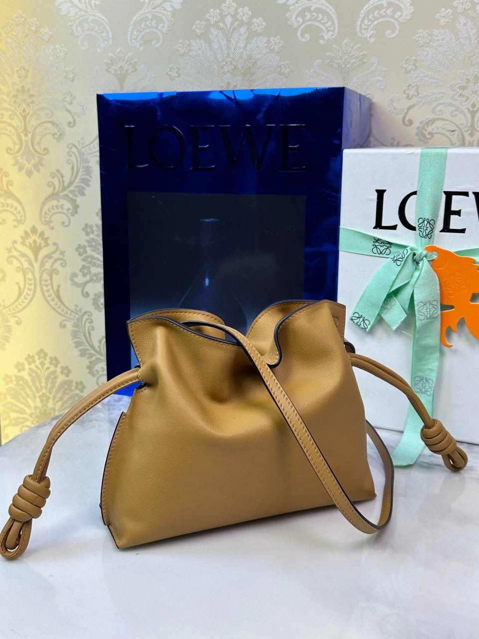 Flamenco clutch ✦迷你✦ 尺寸：𝟐𝟐.𝟓-𝟏𝟖-𝟗𝐜𝐦 型号：052030 棕色 ❤️mini flamenco clutch bag 可手拿亦可优雅斜挎 云朵般温暖亦轻盈的造型如此简单，💯耐看💯不会out的款式！ ❤️包袋采用进口小牛皮，手感如羊皮般细腻柔软，却比羊皮更加结实耐用，麂皮内衬 ❤️品牌标志性绳结设计，收紧袋口就是小福袋造型，超Q，看着不大实际超会装😇