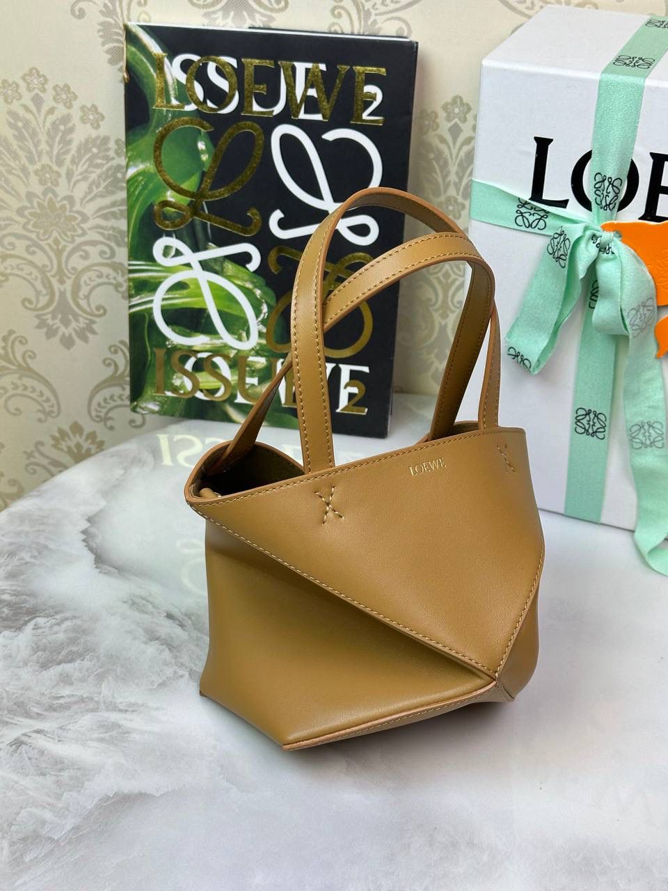 *𝐌𝐢𝐧𝐢 𝐏𝐮𝐳𝐳𝐥𝐞 𝐅𝐨𝐥𝐝折叠手袋👜* ——全新【𝗡𝗘𝗪】升级‼️ 延续经典𝙋𝙪𝙯𝙯𝙡𝙚的标志性几何裁剪设计，新晋顶流🅰️𝙋𝙪𝙯𝙯𝙡𝙚 𝙁𝙤𝙡𝙚 𝙏𝙤𝙩𝙚以折纸包为灵感，升级成🉑完全折叠‼️的结构，立体与平面任意切换，出差旅行🧳必备单品。小牛皮材质轻且柔软，𝐌𝐢𝐧𝐢尺寸搭配一条可拆卸式肩带，手提，肩背，斜挎多样化背法✨ 尺寸：𝟏𝟔.𝟓-𝟗.𝟓-𝟐𝟎cm 款号：052322