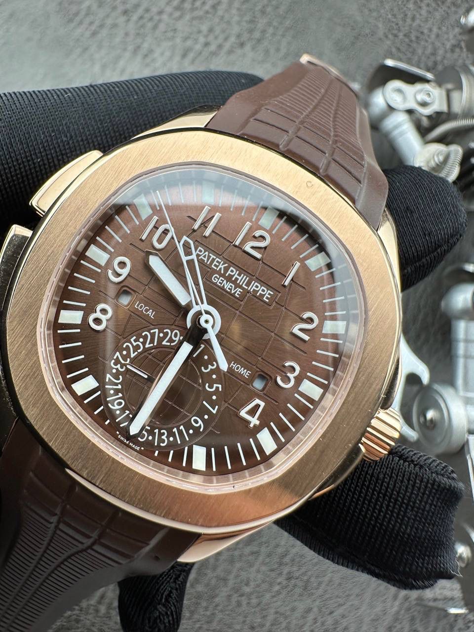 百达翡丽Aquanaut系列😎 【表壳】40.8MM表径，不锈钢材质，圆润的八角壳型恰到好处，表壳左侧的鲨鱼鳍型设计，是可以前后快调中央镂空时针的按钮，这枚指针可以用来指示第二时区时间。 【表盘】黑色浮雕表盘，金属立体字块，覆荧光涂层时标。3、9点钟分别显示”HOME”与”LOCAL”的方形昼夜视窗，蓝白二色各自代表晚上与白天，6点钟位置是指针式的日期盘。 【机芯】成功实现百达翡丽5164A-001内载的324 SC FUS自动上链机芯功能，大三针基础机芯上搭载两地时间模组。 配有休闲气息的Tropical表带，正是为年轻世代所准备的奢华运动表。