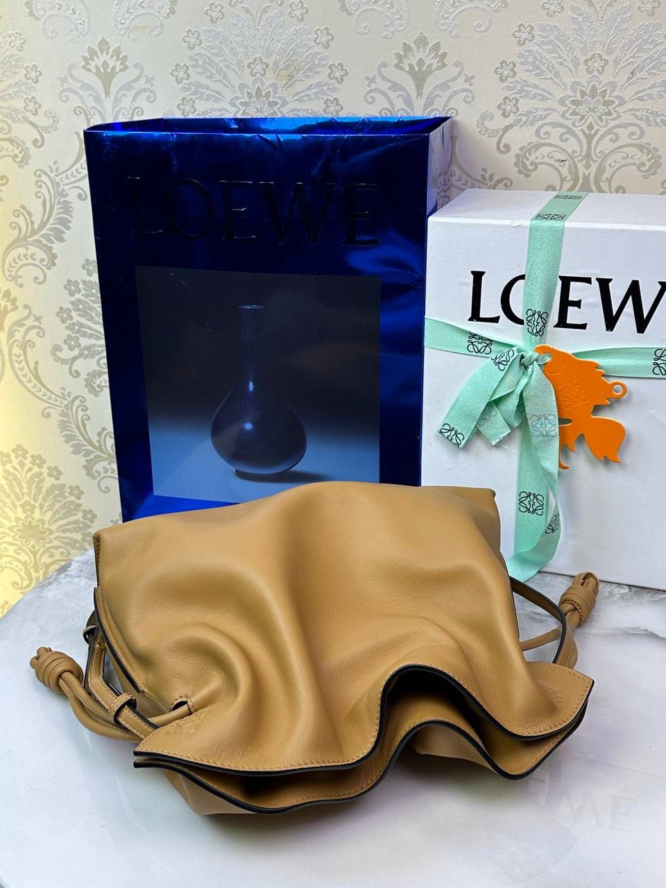 Flamenco clutch✦中号✦ 尺寸：𝟑𝟎-𝟐𝟒.𝟓-𝟏𝟎.𝟓𝐜𝐦 型号：052028 棕色 ❤️flamenco clutch bag可手拿亦可优雅斜挎 云朵般温暖亦轻盈的造型如此简单，💯耐看💯不会out的款式！ ❤️包袋采用进口小牛皮，手感如羊皮般细腻柔软，却比羊皮更加结实耐用，麂皮内衬 ❤️品牌标志性绳结设计，收紧袋口就是小福袋造型，超Q，看着不大实际超会装😇