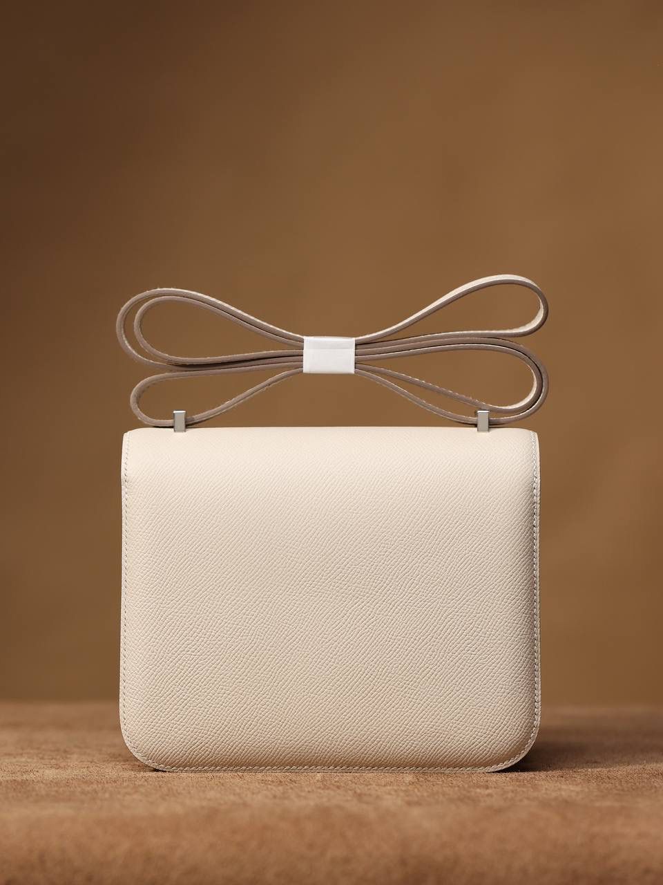Hermes 爱马仕 #Constance 19奶昔白银扣👜✨ Epsom牛皮 单肩斜挎包 尺寸：19*15*4 cm 这款采用的是Epsom牛皮,纯原皮，和专柜用的是一个渠道的真皮 什么是Epsom牛皮？ 皮质：ep皮/手掌纹、一岁以上的公牛皮 软硬度：偏硬 纹理：皮面颗粒小的细腻皮纹，有点光泽感 特点：硬朗有细纹的牛皮皮质。细纹是进过后期处理的，比较硬质立体，长期贮存也不容易变形。自重轻，不易刮伤，非常耐磨实用。 所以每个H的款式用的皮都不一样，都是非常有讲究的✅