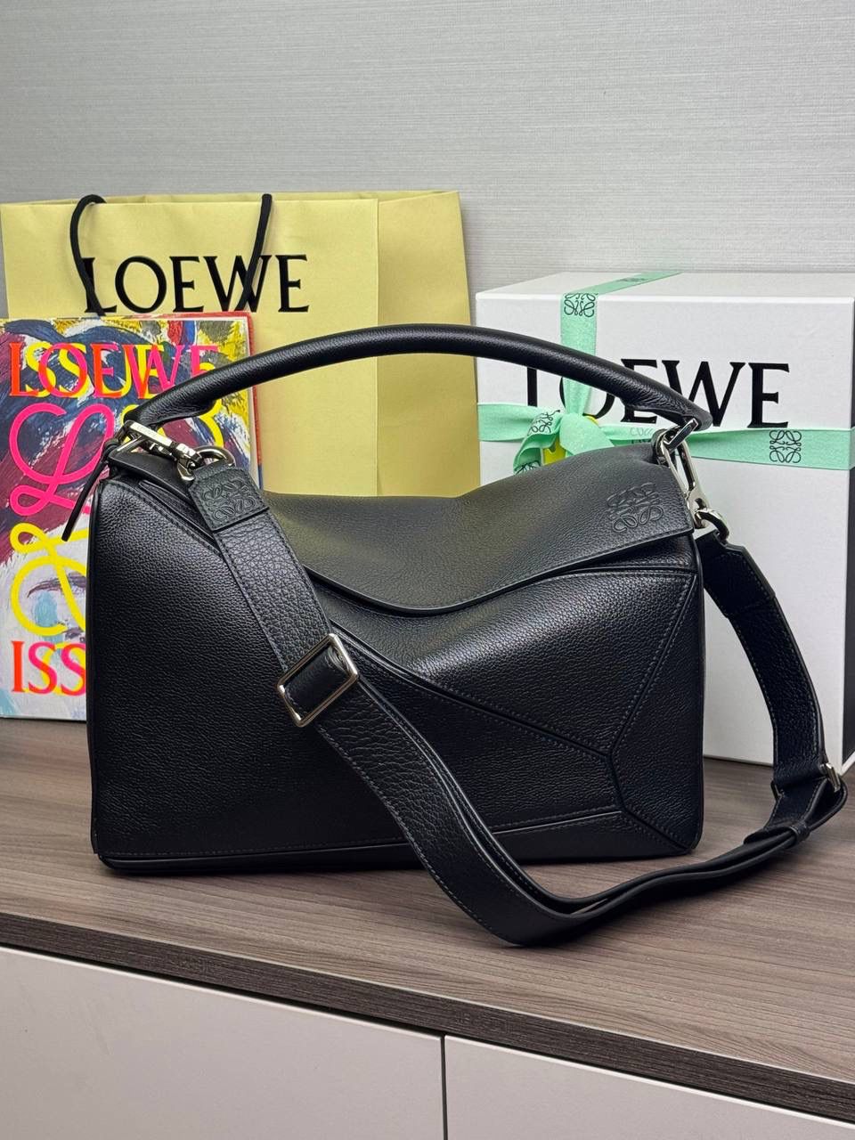 🎈【全钢】大号鹿皮𝘗𝘶𝘻𝘻𝘭𝘦* ——【👉🏻黑色到货✅】 尺寸：𝟑𝟐.𝟓-𝟏𝟒.𝟓-𝟐𝟑.𝟓𝐜𝐦 编码：260403 【配全套包装】 ❤️经典拼图系列•不规则立体几何设计•最具辨识度的立体廓形和几何美学•顶级进口皮搭配德国沙菲线•独家定制五金•𝗬𝗞𝗞拉链拉头。 ❤️该款大号采用鹿皮革制成•绒面内里•搭配一条可拆卸可调节的皮肩带•肩背斜挎或手提多样化背法。