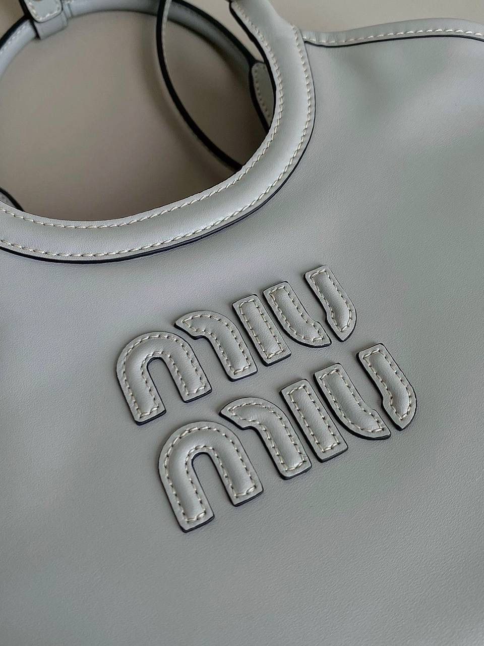 🈶冰蓝小号 𝗠𝗶𝘂𝗠𝗶𝘂托特！！ 近年miu家真的很会，都是心头爱 慵懒惬意的敞口托特搭配弧形包口 同色系浮雕logo低调又高级 软而不塌的全牛皮质感绝！ 中号大气的包身，男生女生都能驾驭 随时随地的凹造型 小号可以斜挎 小巧可爱，可太适合霓虹妹了 被痕痕拿捏住了🤙🏻 22×12×32cm #F0120m