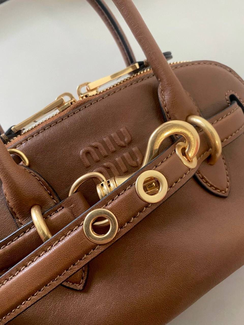 🈶焦糖色，迷你 𝗠𝗶𝘂𝗠𝗶𝘂24秋冬贝壳包 年度爆炸款来啦 | 真心被夸爆 没有过分夸张的设计，有着时髦且个性的圆弧包型，形似贝壳，看着很轻松又舒适一点也不会给人压力 双向拉链在保证实用性的同时让它充满了复古的调性，搭配上腰带式设计细节，时髦有态度 面料手感软糯，拎在手上可以切确感受到高级质感 迷你：8×13×21cm #F0022m 小号：16.5x28x10cm 大号：33x17x11cm