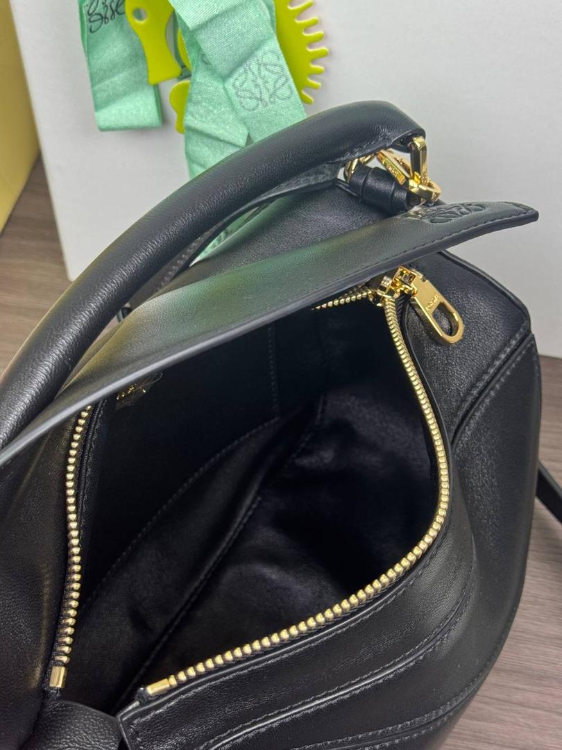 🎈【周年限定】 小号纳帕羊皮𝗙𝗲𝗮𝘁𝗵𝗲𝗿𝗹𝗶𝗴𝗵𝘁 𝗣𝘂𝘇𝘇𝗹𝗲手袋👜 ——黑色到货❤️ 尺寸：𝟮𝟰-𝟭𝟬.𝟱-𝟭𝟲.𝟱𝗰𝗺 编码：061610【配全套礼盒】 ✅延续经典老款𝗣𝘂𝘇𝘇𝗹𝗲做法，全新𝗣𝘂𝘇𝘇𝗹𝗲内外采用柔软轻盈的纳帕羊皮材质，为手袋注入随性慵懒的风格。 ✅该款饰有旋转卡扣，铰链式拉链头，一个外部拉链后袋，一个内部插袋，以及可拆卸式的𝗟𝗢𝗘𝗪𝗘烫金或烫银标签，饰有隐秘口袋和气球骰子，底部长方形金属脚钉。搭配可拆卸可调节长肩带，可肩背、斜挎或手提。