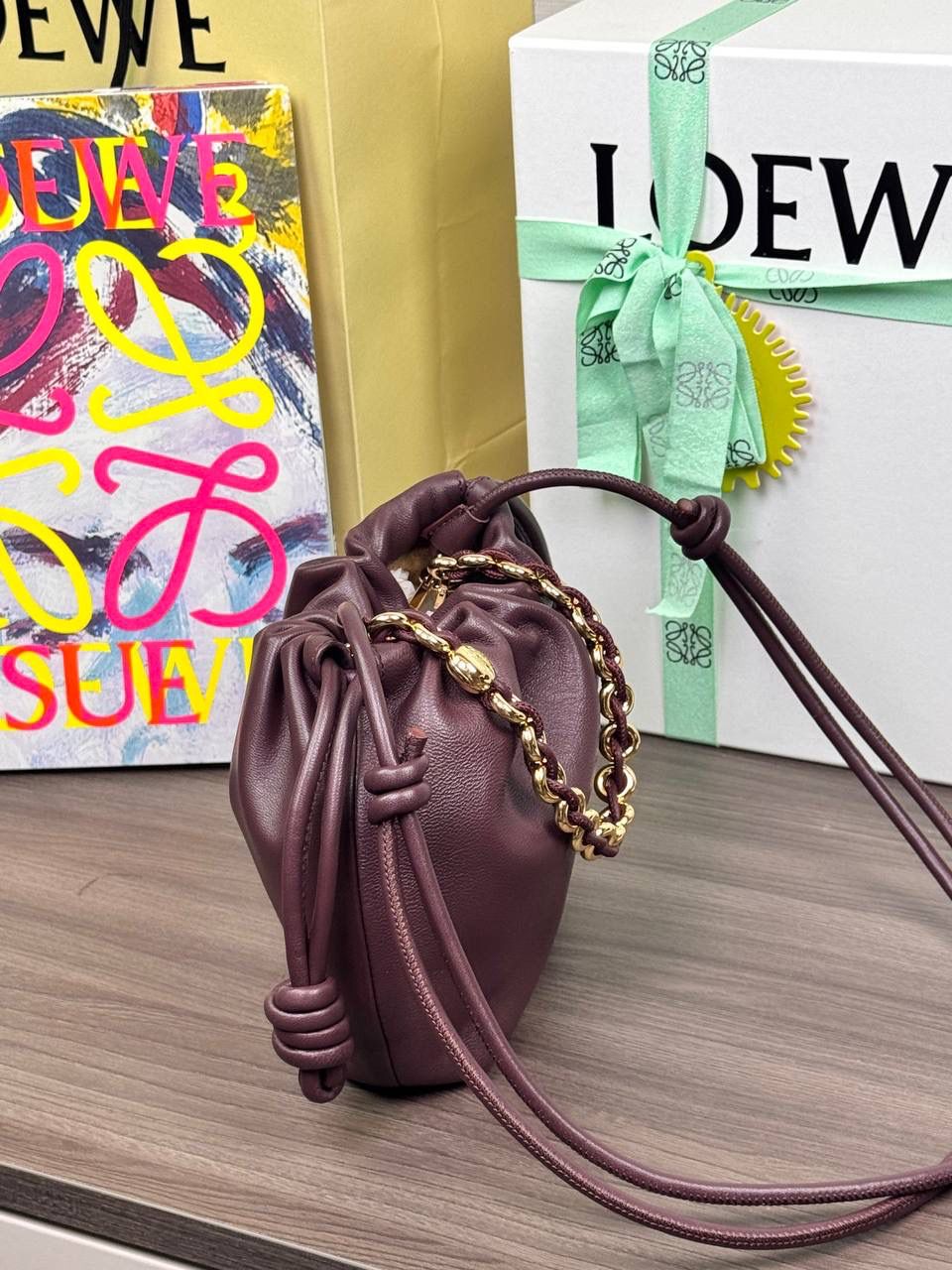 🎈迷你链条款𝙁𝙡𝙖𝙢𝙚𝙣𝙘𝙤 𝙋𝙪𝙧𝙨𝙚羊皮 ——【勃艮第红】 尺寸：𝟐𝟑.𝟓-𝟓-𝟏𝟕𝐜𝐦 编码：062347 👉🏻延续福袋收缩绳褶皱设计，羊皮包身手感细腻柔软❤️ 👉🏻链条肩带➕皮肩带的双肩带设计，时尚百搭，给足了集美们多样化的选择。肩带可拆卸可调节，磁扣开合，正面烫金𝙇𝙤𝙜𝙤，呈现出高贵典雅的视觉感😍 👉🏻独家背景➕独家品质➕独家全套砖柜礼盒套装，市场高端品质皆在我手✌🏻