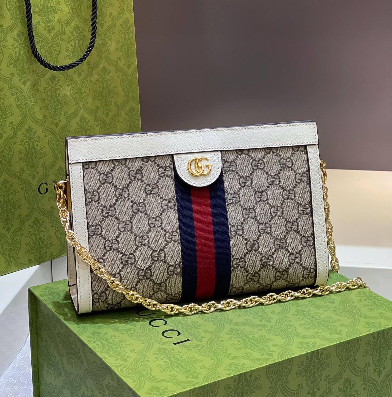 ✈️✈️✈️🔥爆款𝐎𝐩𝐡𝐢𝐝𝐚 信封包# ▫️型号：503877（原厂皮） ▫️尺寸：26*17.5*8cm 销量王👑经典高级人造帆布配以嵌花织带条纹，彩用白色皮革滚边，前面采用椭圆形皮革标签，配以金黄色双GG五金，以磁扣安全闭合，有两个隔层，容量大，链式肩带的搭配。整款包包打开像扇形，很有美感，难怪它在市场很烫，很抢手🔥🔥