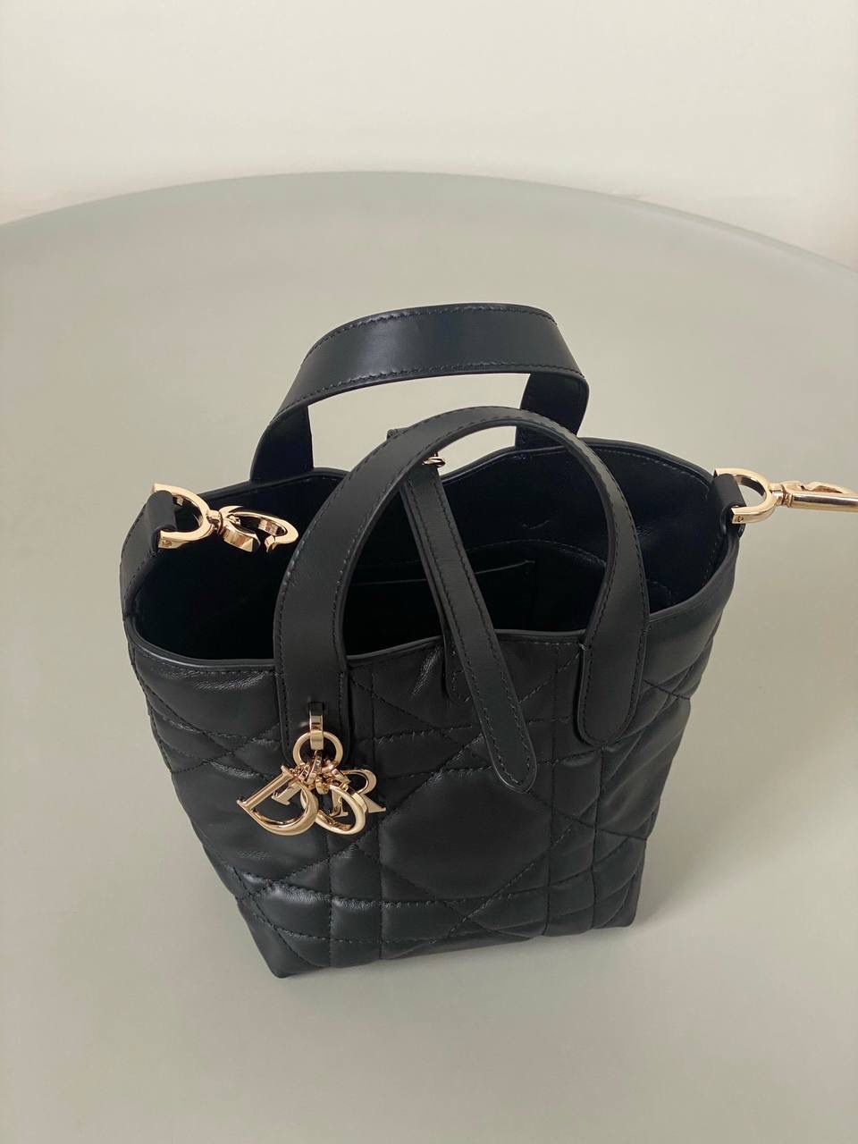 🈶黑色，迷你 𝗗𝗜𝗢𝗥 𝗧𝗼𝘂𝗷𝗼𝘂𝗿𝘀新版竖款 火爆全网toujours缩小版来啦！ 看到真的心动得不行～ 实物就是常规迷你水桶大小， 真的可爱死 别说，包虽小但容量还挺大的 日常用品都能轻松装上 肩带长度也刚刚好，不挑身高 反正就是太乖啦！夏日必备 😍 迷你：13×15×12cm #M1272m 中号：20x22x18.5cm 小号：16x18x12cm