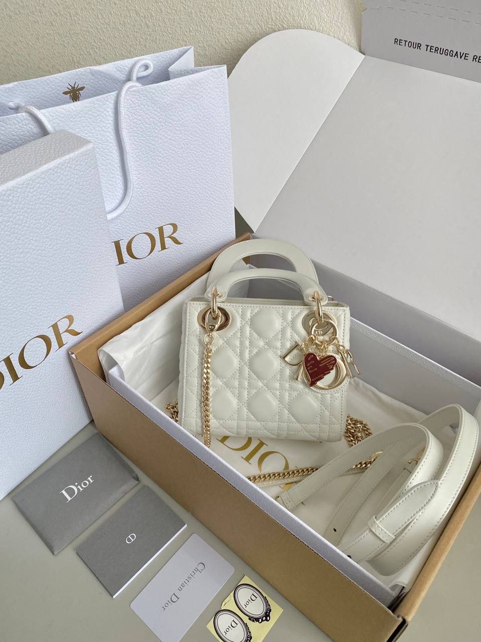 白色🌟 三格 𝗗𝗜𝗢𝗥 𝗟𝗮𝗱𝘆七夕限定 在经典的基础上加了爱心小挂饰 让整个氛围有了爱的烂漫气息 戴妃作为经典的代表，怎么买怎么对 特别手拎时会显得整个人非常温柔优雅 我一直都推荐女生一定要有一只经典款！！ 每个颜色都好好看，完全不需太纠结😍💓 17×15×7cm