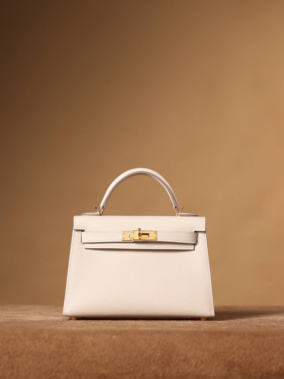 HERMES 爱马仕 Mini Kelly 二代 👜✨ Mini Kelly 二代 奶昔白金扣 高清实拍图 尺寸：19*12*6cm Hermès爱马仕是世界著名的奢侈品品牌，1837年由Thierry Hermès创立于法国巴黎。爱马仕早年以制造高级马具起家，迄今已有180年的悠久历史。 其整个品牌从整体到细节以及专卖店，都弥漫着浓郁的以马文化为中心的深厚底蕴🎀