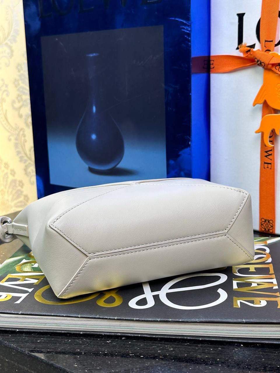 ♥️𝙋𝙪𝙯𝙯𝙡𝙚 𝙁𝙤𝙡𝙙 ——【海盐白】 尺寸：𝟐𝟑-𝟔.𝟓-𝟏𝟓.𝟓𝐜𝐦 编码：522404 🎈经典几何为造型，以及柔软细腻的Napa牛皮，升级为可完全折叠的手拿包。 🎈自带一根🉑拆卸🉑调节的肩带，一包多背，多样化风格，秀场大放异彩😃日常实用性强👌 🎈配全套专柜礼盒🎁，给你满满的仪式感👀