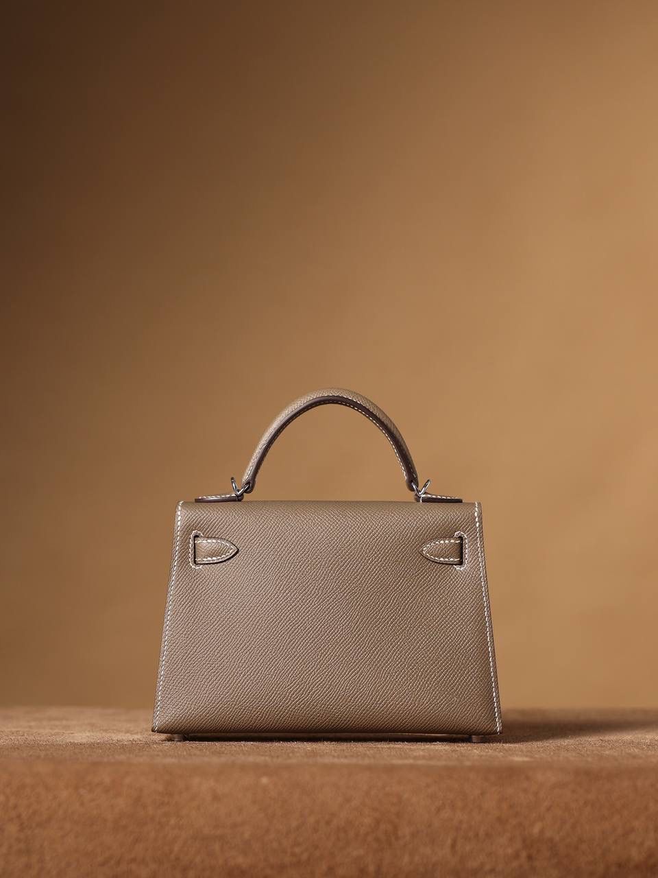 HERMES 爱马仕 Mini Kelly 二代 👜✨ Mini Kelly 二代 大象灰银扣 高清实拍图 尺寸：19*12*6cm Hermès爱马仕是世界著名的奢侈品品牌，1837年由Thierry Hermès创立于法国巴黎。爱马仕早年以制造高级马具起家，迄今已有180年的悠久历史。 其整个品牌从整体到细节以及专卖店，都弥漫着浓郁的以马文化为中心的深厚底蕴🎀