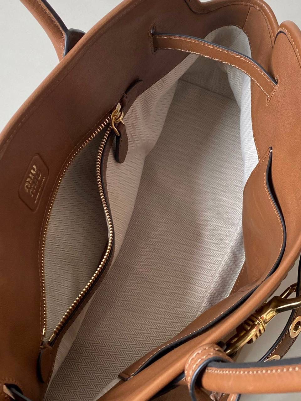 🈶焦糖色， 𝗠𝗶𝘂𝗠𝗶𝘂 手提包·横版 这只Aventure我要夸爆它！ 绝对是公文包中的颜值天花板 这款有多难买不用多说，绝对的断货王 酷酷的慵懒感洋气且时髦 还有一丢vintage感，超有调 上班通勤，日常出街都超出片 22.5×44×14.5cm #F0023m