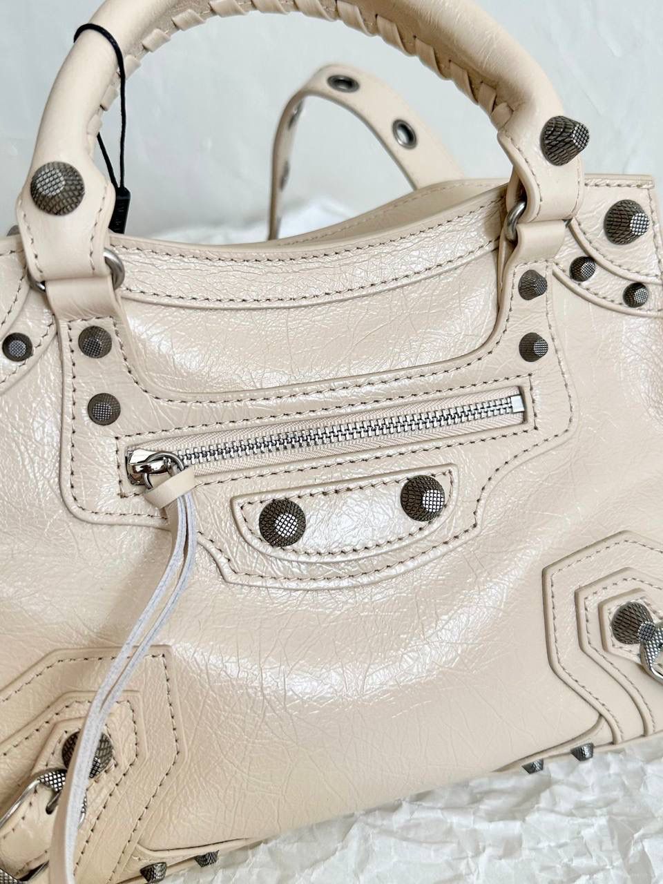 neo cagole 机车包xs奶茶色🥟 首先声明，我爱一切机车元素 无论是le cagole还是这只neo 喜欢大容量的姐妹冲这只 油蜡皮的不规则摔纹配上大量的五金配件 还有流苏拉牌➕爱心镜子➕零钱包挂件 极繁的魅力由此而来～ 辣妹酷妹冲冲！ 26×17.8×11.4cm700940m