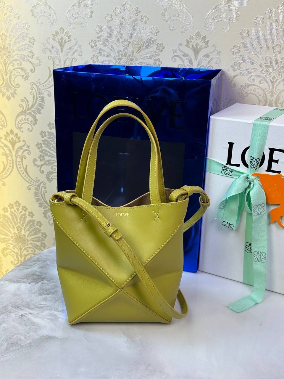 *𝐏𝐮𝐳𝐳𝐥𝐞 𝐅𝐨𝐥𝐝折叠手袋👜* ——全新【𝗡𝗘𝗪】升级‼️ 延续经典𝙋𝙪𝙯𝙯𝙡𝙚的标志性几何裁剪设计，新晋顶流🅰️𝙋𝙪𝙯𝙯𝙡𝙚 𝙁𝙤𝙡𝙚 𝙏𝙤𝙩𝙚以折纸包为灵感，升级成🉑完全折叠‼️的结构，立体与平面任意切换，出差旅行🧳必备单品。小牛皮材质轻且柔软，𝐌𝐢𝐧𝐢尺寸搭配一条可拆卸式肩带，手提，肩背，斜挎多样化背法✨ 尺寸：𝟏𝟔.𝟓-𝟗.𝟓-𝟐𝟎𝐜𝐦 款号：052322