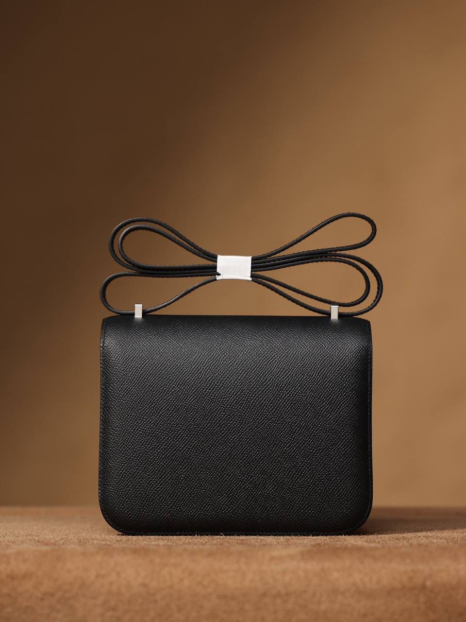 Hermes 爱马仕 #Constance 19黑色银扣👜✨ Epsom牛皮 单肩斜挎包 尺寸：19*15*4 cm 这款采用的是Epsom牛皮,纯原皮，和专柜用的是一个渠道的真皮 什么是Epsom牛皮？ 皮质：ep皮/手掌纹、一岁以上的公牛皮 软硬度：偏硬 纹理：皮面颗粒小的细腻皮纹，有点光泽感 特点：硬朗有细纹的牛皮皮质。细纹是进过后期处理的，比较硬质立体，长期贮存也不容易变形。自重轻，不易刮伤，非常耐磨实用。 所以每个H的款式用的皮都不一样，都是非常有讲究的✅