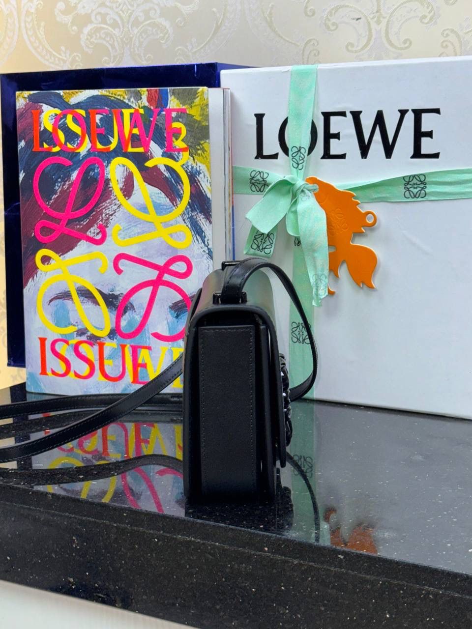 🎈单色釉𝘎𝘰𝘺𝘢*缎面皮 —【黑色到货✅】 尺寸：𝟏𝟗-𝟔-𝟏𝟑.𝟓𝐜𝐦 编码：262123 【配全套礼盒】 ✅汲取古代单色釉瓷器色彩灵感，全新打造𝘓𝘰𝘸𝘦*单色釉系列。该款采用缎面丝绸牛皮搭配内里纳帕羊皮，手感丝滑细腻。正面立体膨胀𝘈𝘯𝘨𝘳𝘢𝘮 𝘓𝘰𝘨𝘰设计搭配陶瓷小兔子挂饰，堪称时尚界的艺术品。 ✅磁扣开合，内部3个隔层设计，以及按扣和背面小侧袋，收纳方便➕安全感满分，能装，好搭。