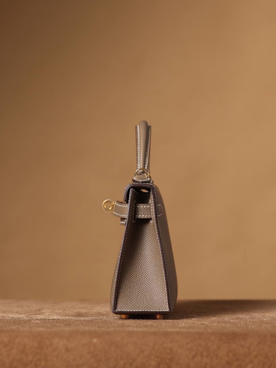 HERMES 爱马仕 Mini Kelly 二代 👜✨ Mini Kelly 二代 大象灰金扣 高清实拍图 尺寸：19*12*6cm Hermès爱马仕是世界著名的奢侈品品牌，1837年由Thierry Hermès创立于法国巴黎。爱马仕早年以制造高级马具起家，迄今已有180年的悠久历史。 其整个品牌从整体到细节以及专卖店，都弥漫着浓郁的以马文化为中心的深厚底蕴🎀