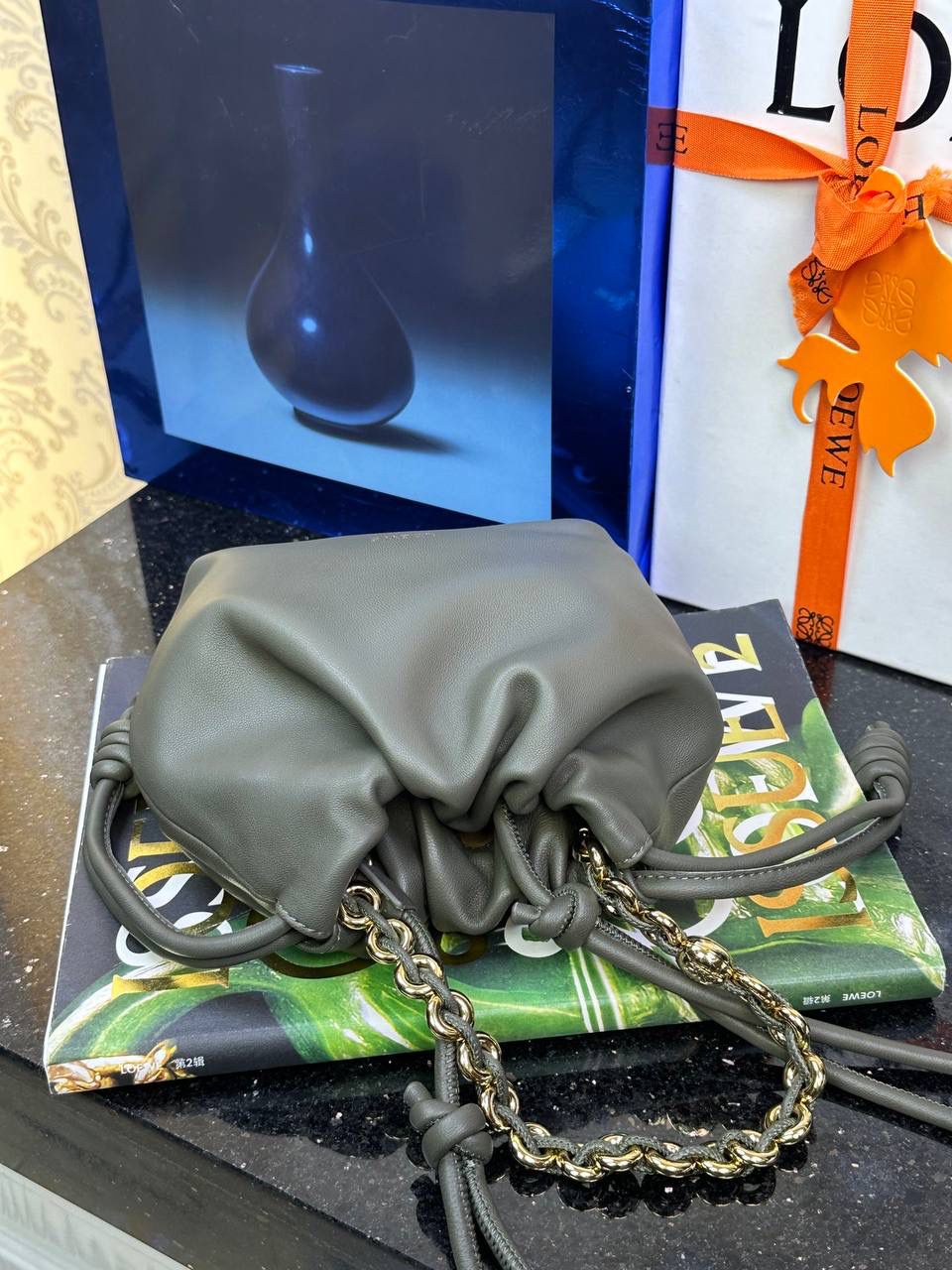 🎈迷你链条款𝙁𝙡𝙖𝙢𝙚𝙣𝙘𝙤 𝙋𝙪𝙧𝙨𝙚羊皮 ——【卡其绿】 尺寸：𝟐𝟑.𝟓-𝟓-𝟏𝟕𝐜𝐦 编码：062347 👉🏻延续福袋收缩绳褶皱设计，羊皮包身手感细腻柔软❤️ 👉🏻链条肩带➕皮肩带的双肩带设计，时尚百搭，给足了集美们多样化的选择。肩带可拆卸可调节，磁扣开合，正面烫金𝙇𝙤𝙜𝙤，呈现出高贵典雅的视觉感😍 👉🏻独家背景➕独家品质➕独家全套砖柜礼盒套装，市场高端品质皆在我手✌🏻